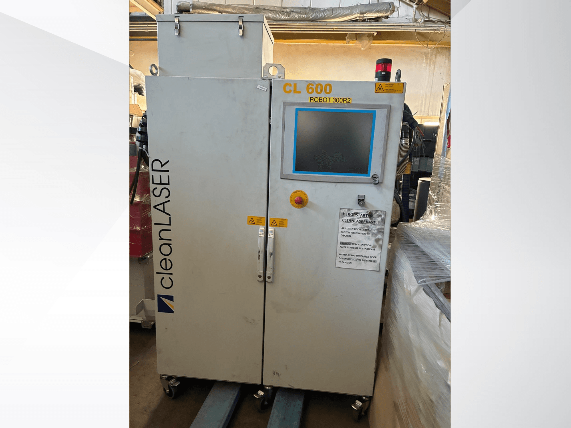 Automatiseringssystemet CLEAN LASER CL 600 sett framifrån med LCD-skärm, varningsetiketter och kontrollknappar på luckan.