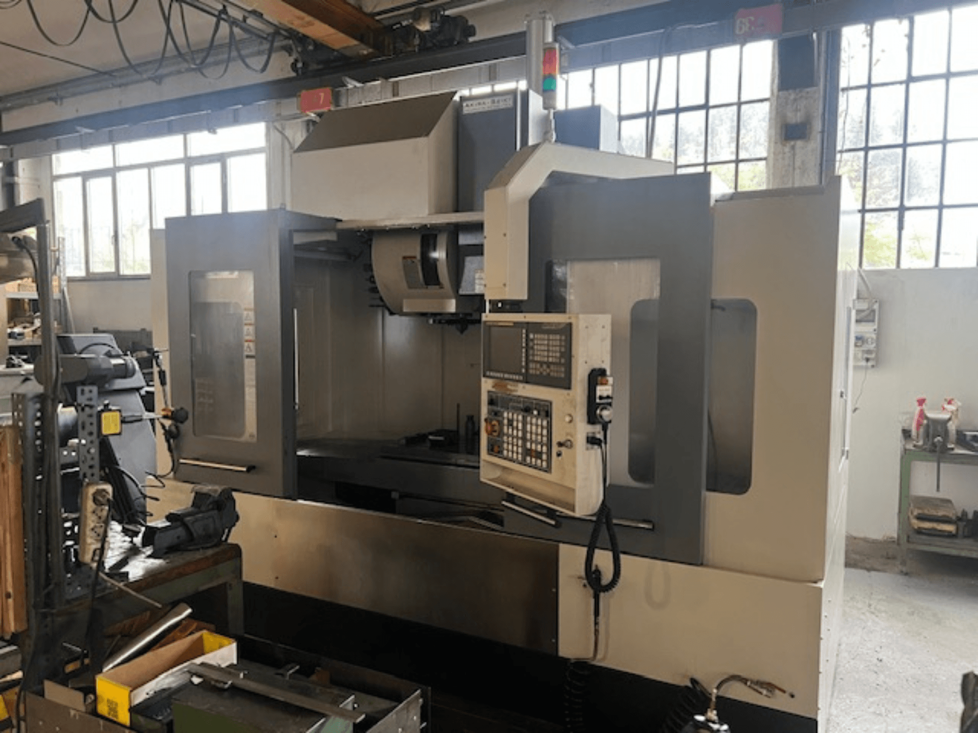 Högteknologisk CNC-fräsmaskin, framifrån, med digitala kontroller, grundläggande säkerhetsindikatorer och en kompakt design.