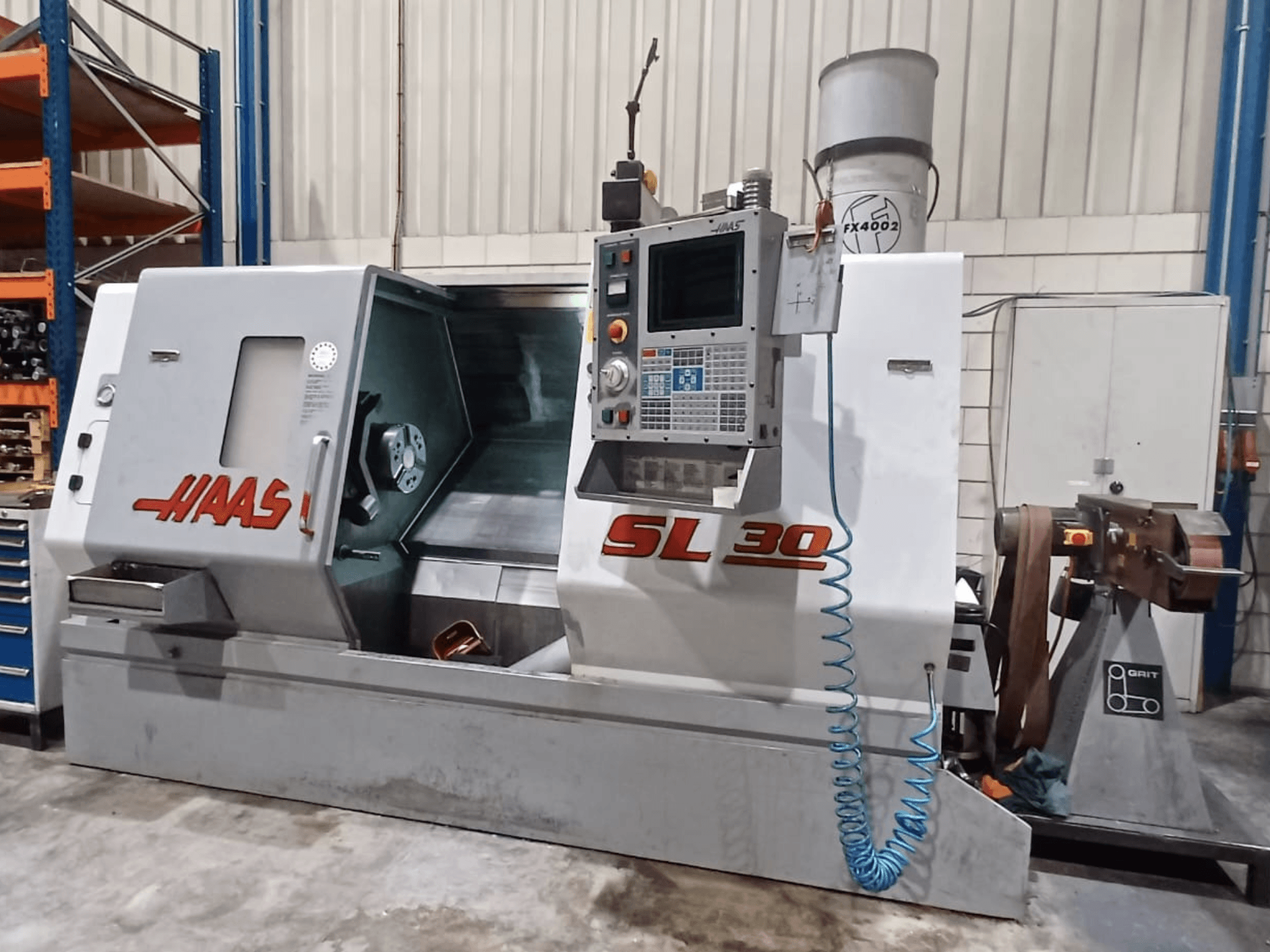 Haas SL 30 CNC-svarv i sidovy som visar kontrollpanelen, bearbetningsområdet och kylsystemet integrerat för metallbearbetning.