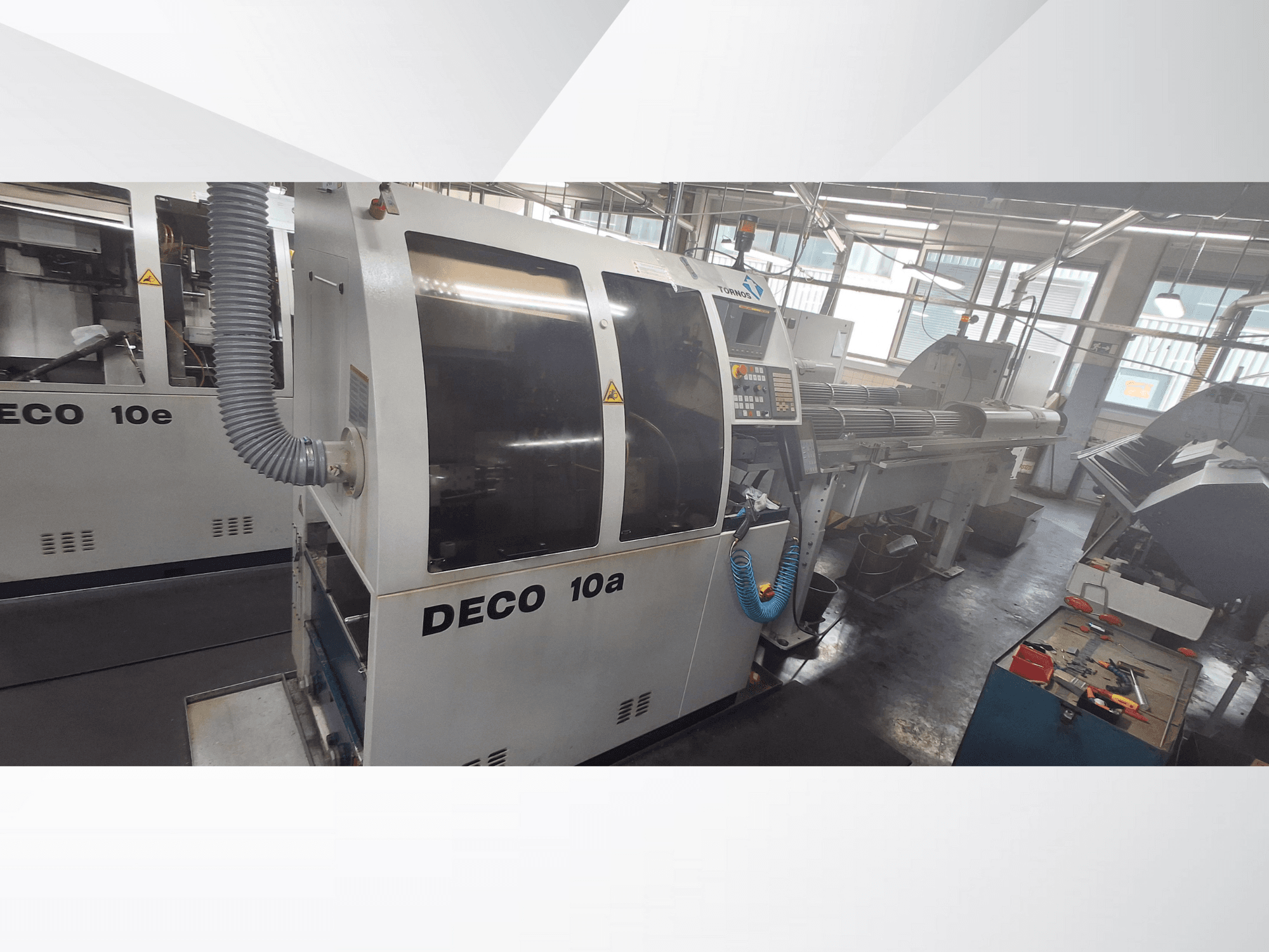DECO 10a CNC-maskin i en verkstad, med frontvy, kontrollpanel och avgassystem. Robust konstruktion och precisionsverktyg.