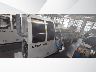 DECO 10a CNC-maskin i en verkstad, med frontvy, kontrollpanel och avgassystem. Robust konstruktion och precisionsverktyg.