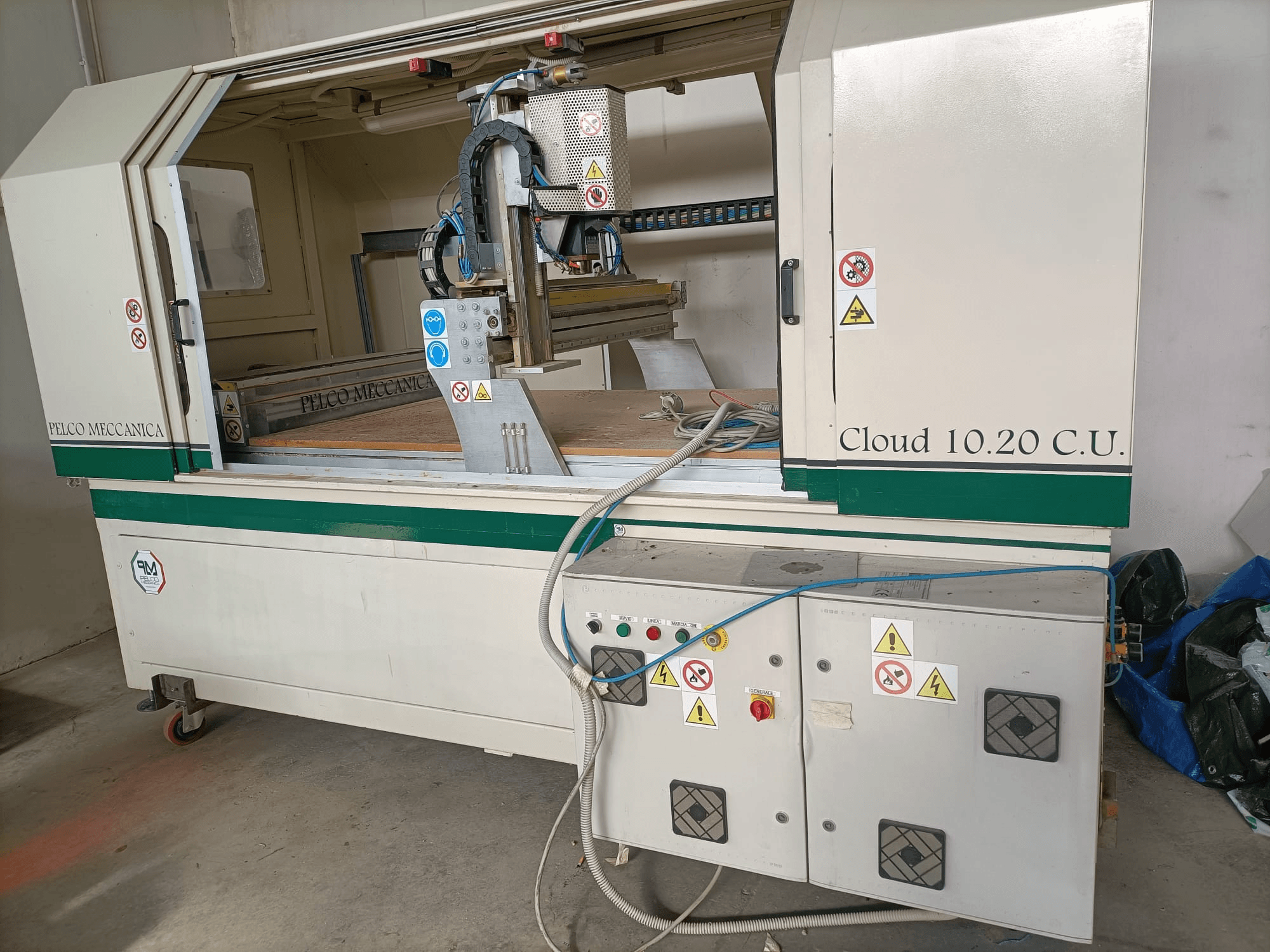 CNC-fräs MECCANICA CLOUD 10.20 C.U., framifrån visar kontrollpanelen och arbetsytan, med säkerhetsetiketter och slangar synliga.