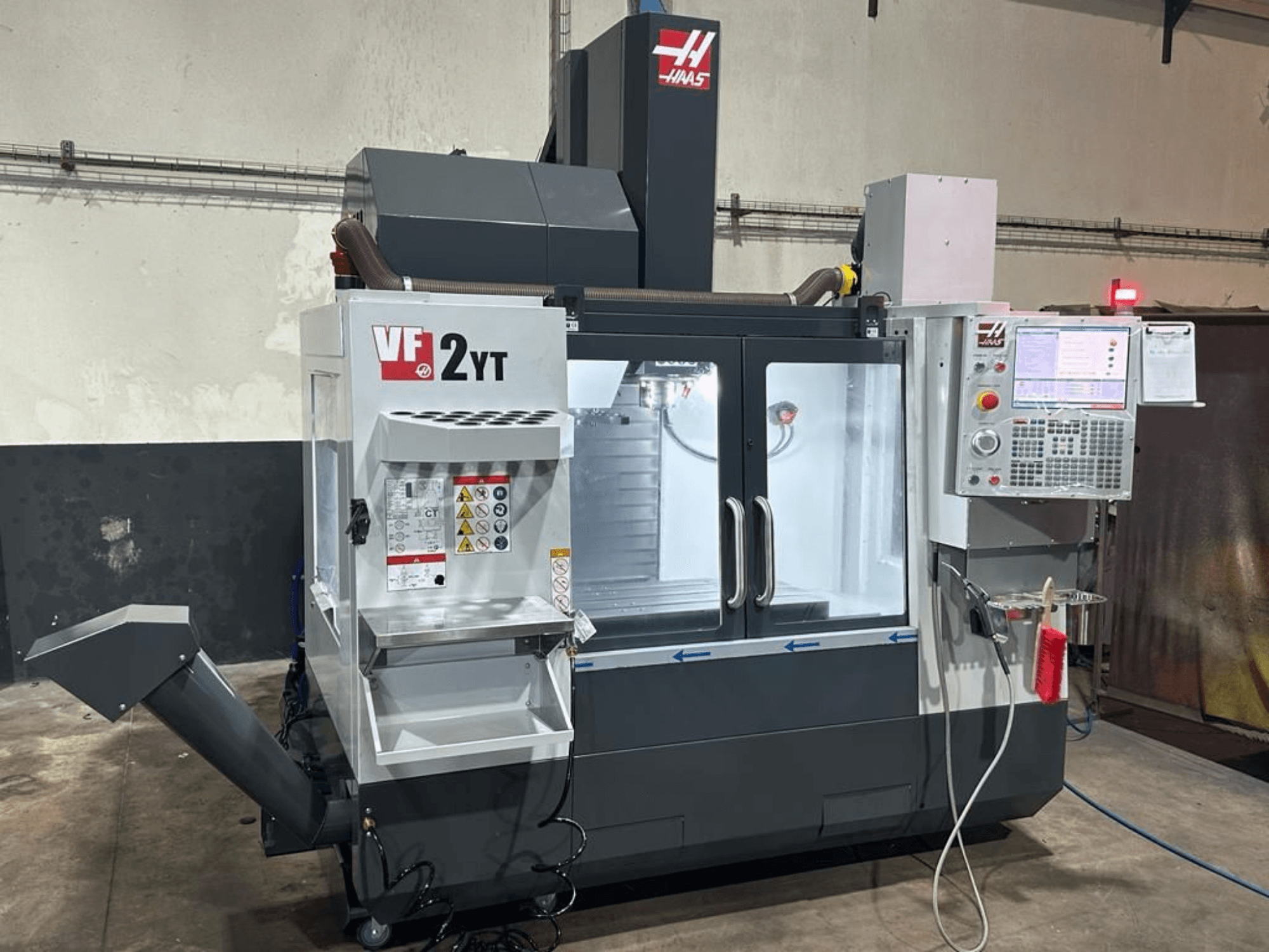 HAAS VF-2YT-EU vertikalt bearbetningscenter sett framifrån, med kontrollpanelen och verktygsförvaringsfacket i förgrunden.