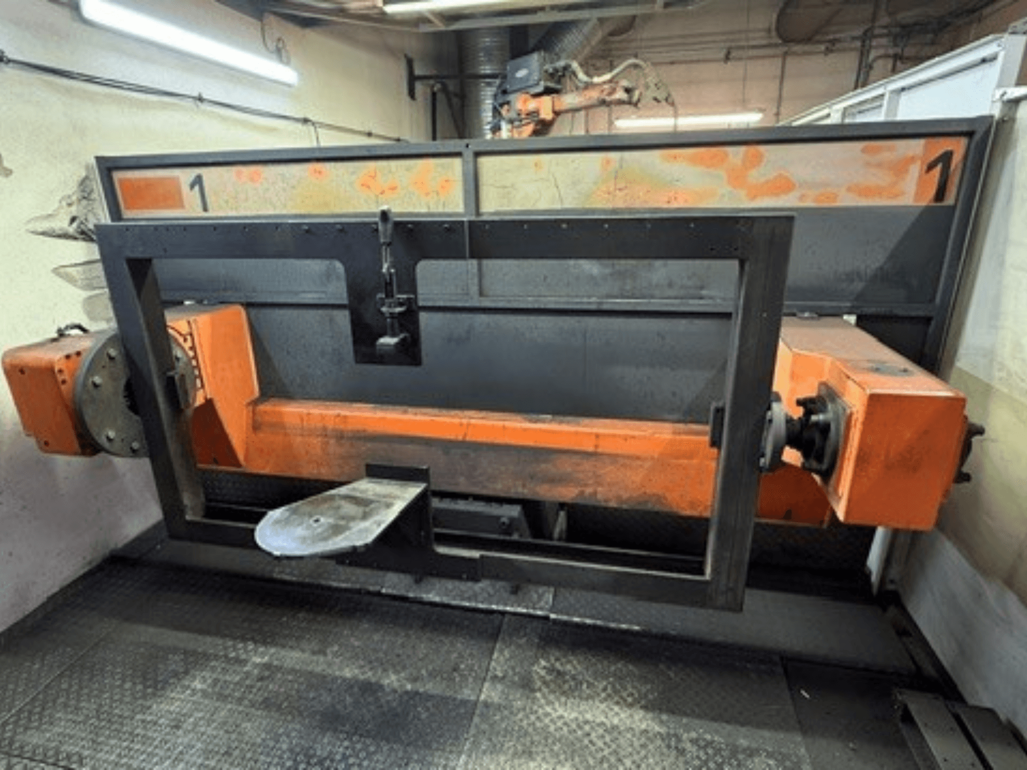 Framifrånvy av svetscellen ABB IRB 2400L, som visar en stor robotram med orange och svarta komponenter i en verkstadsmiljö.