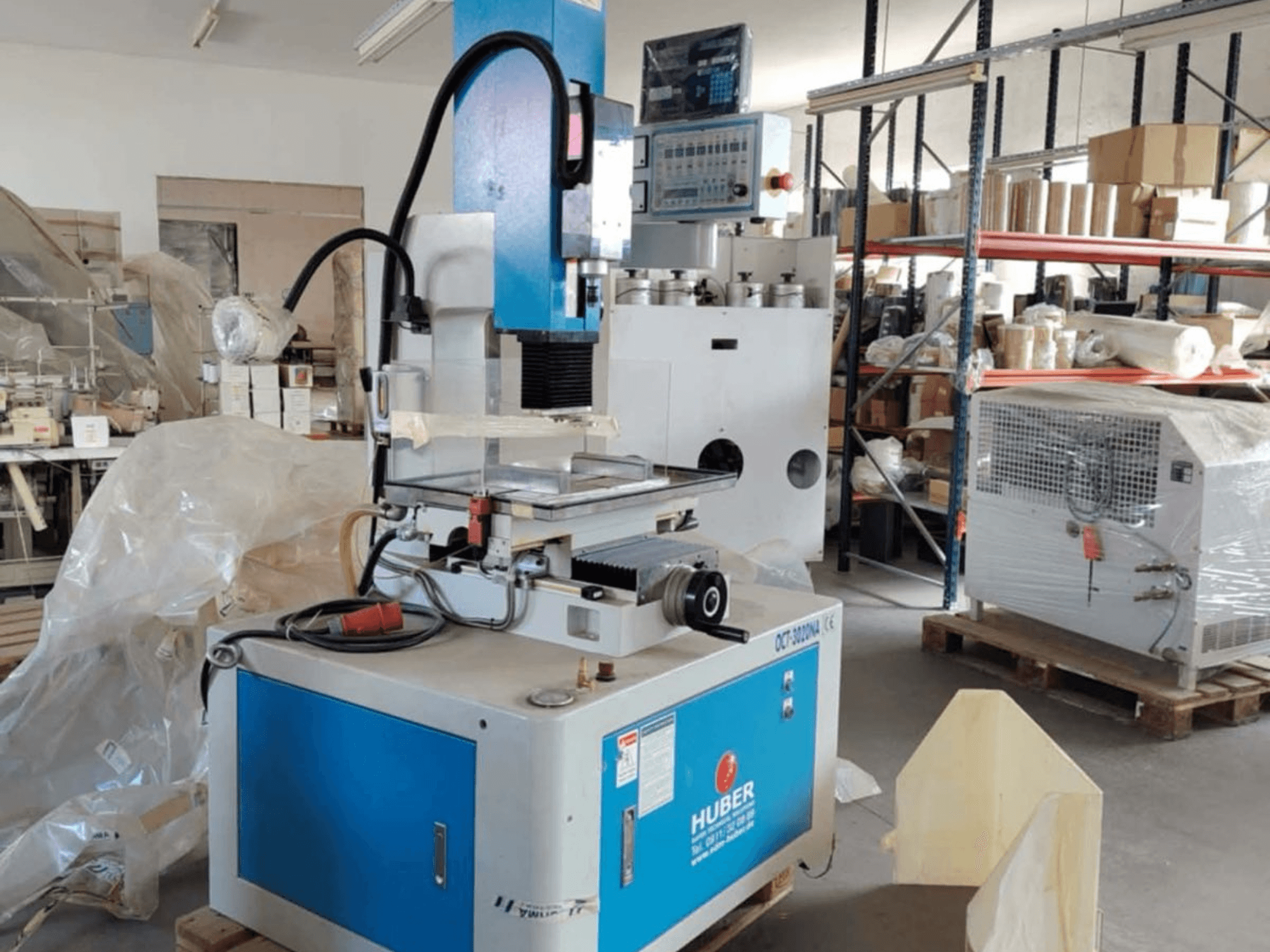 HUBER OCT-3020 NA sänkgnistmaskin i en verkstad, framifrån med blått och grått hölje, digitala kontroller och arbetsområde.