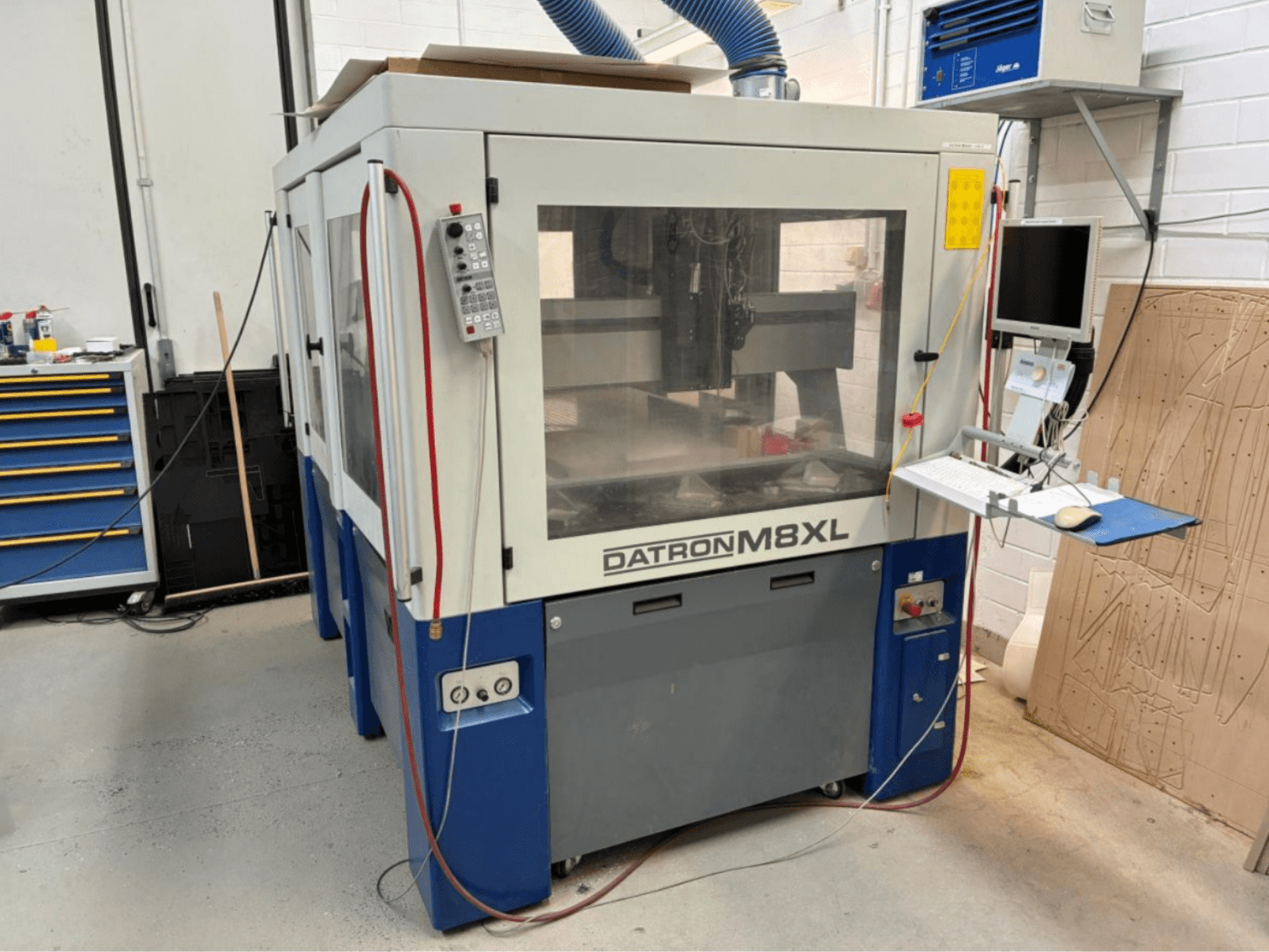 DATRON M8XL CNC-maskin i en verkstad, framifrån med kontrollpanel och monitor monterade bredvid.