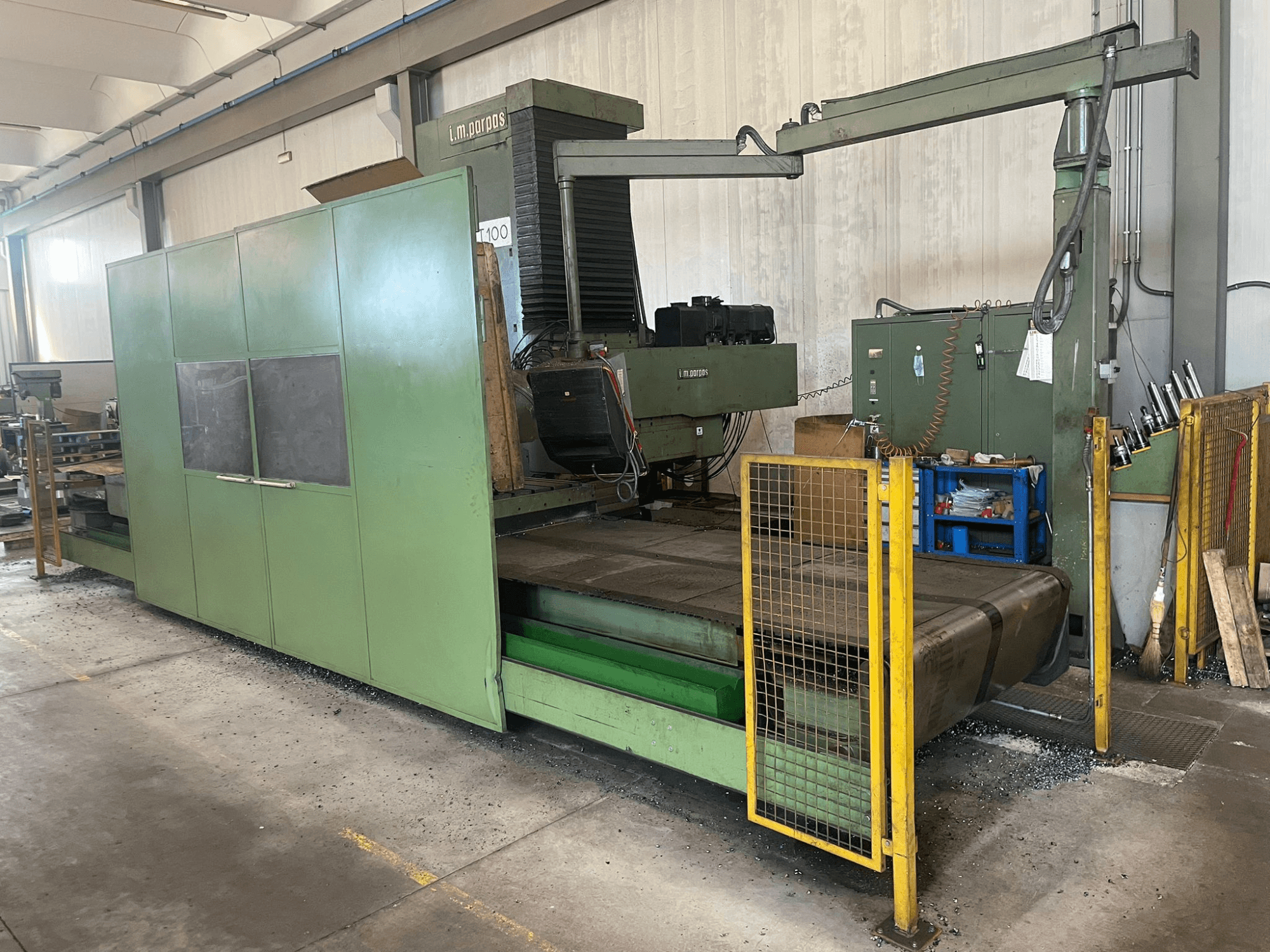 Stor grön industrifräsmaskin med säkerhetsbarriärer, framifrån, med modellbeteckning "l.m. parpas" och synliga reglage.