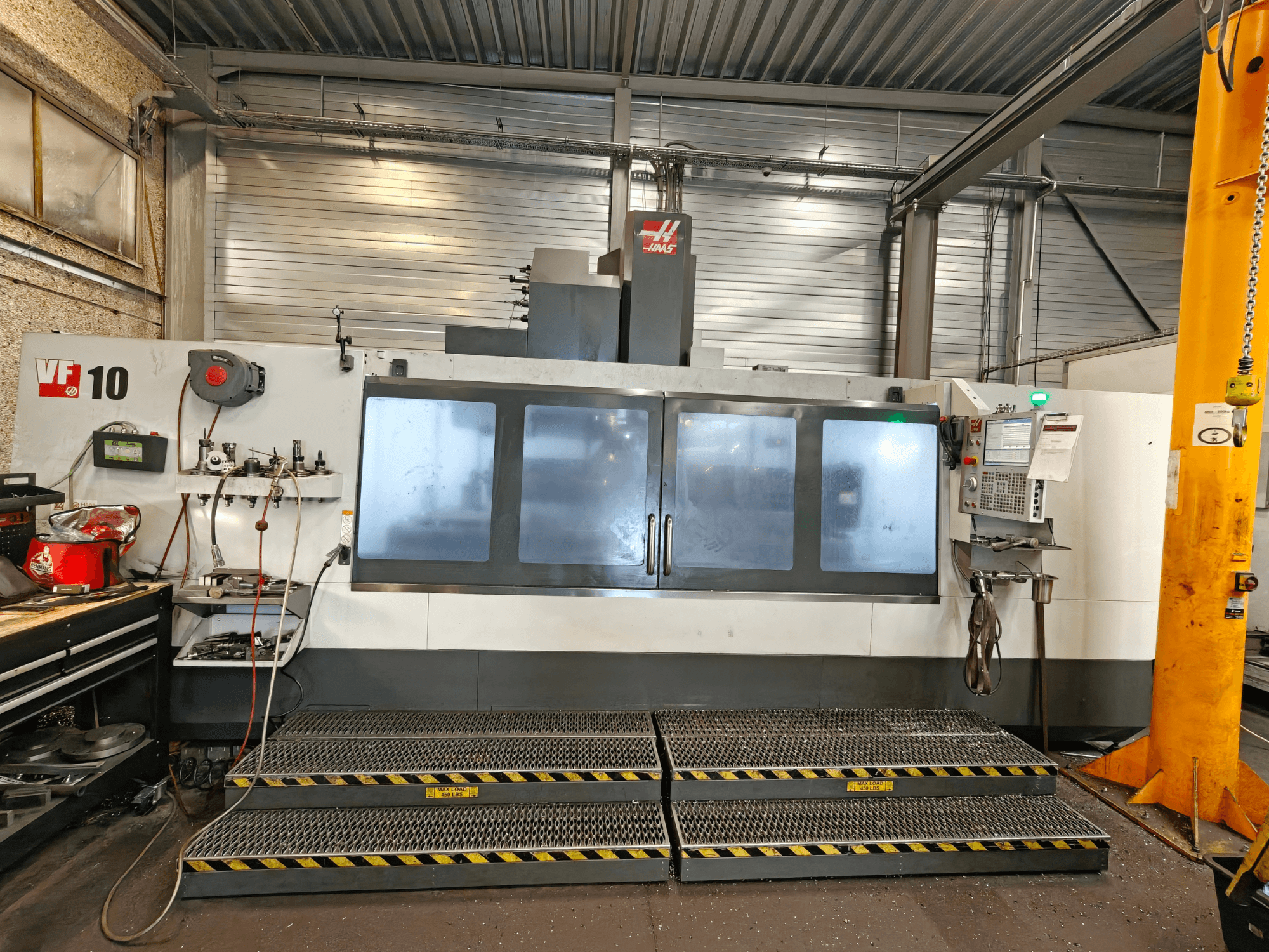 HAAS VF-10/50 vertikalt bearbetningscenter, framifrån, med manöverpaneler och stora siktfönster.