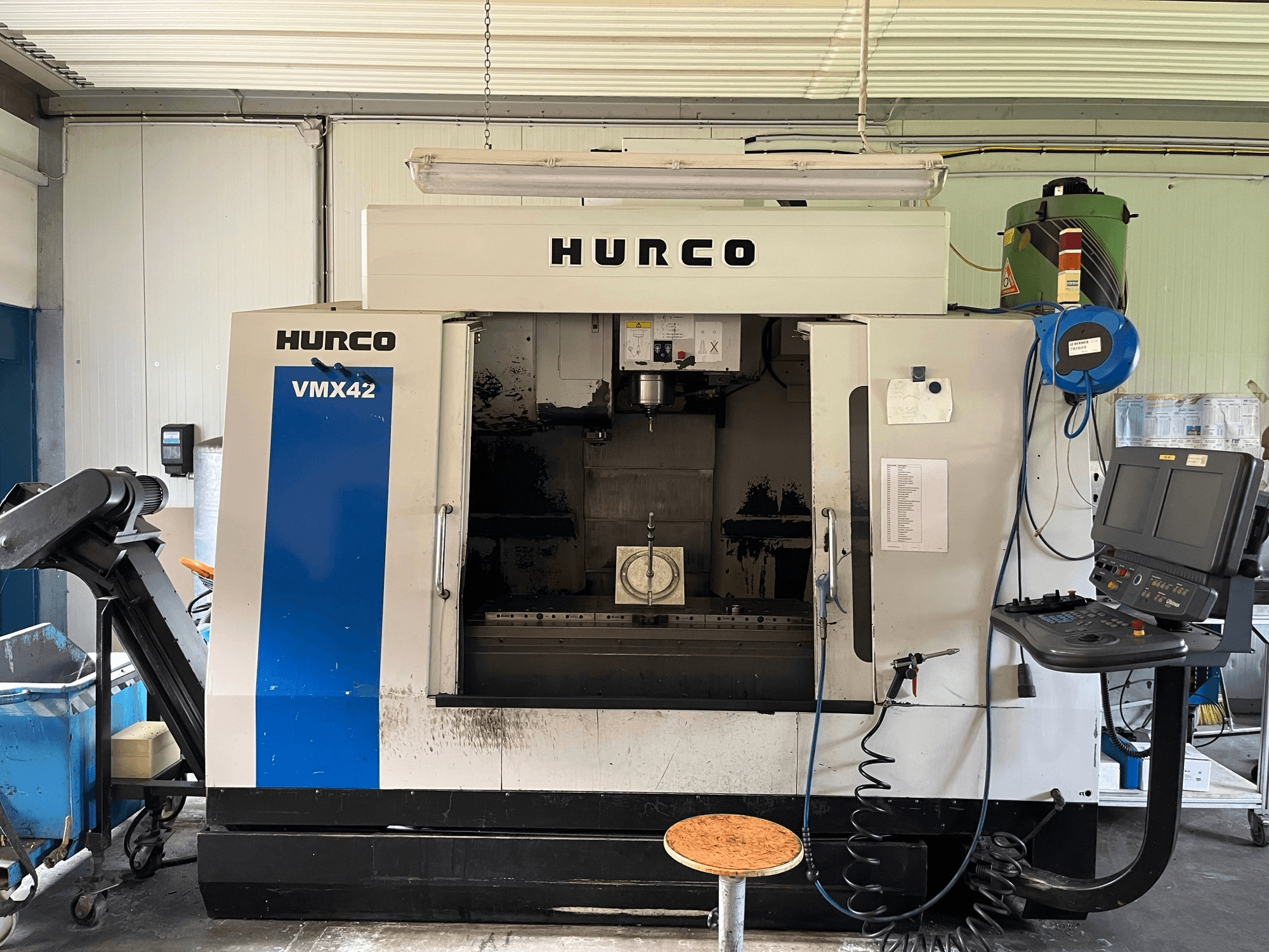 Hurco VMX 42 vertikal fleroperationsmaskin i sidovy, med kontrollpanel, spindel och arbetsstyckesuppställning.