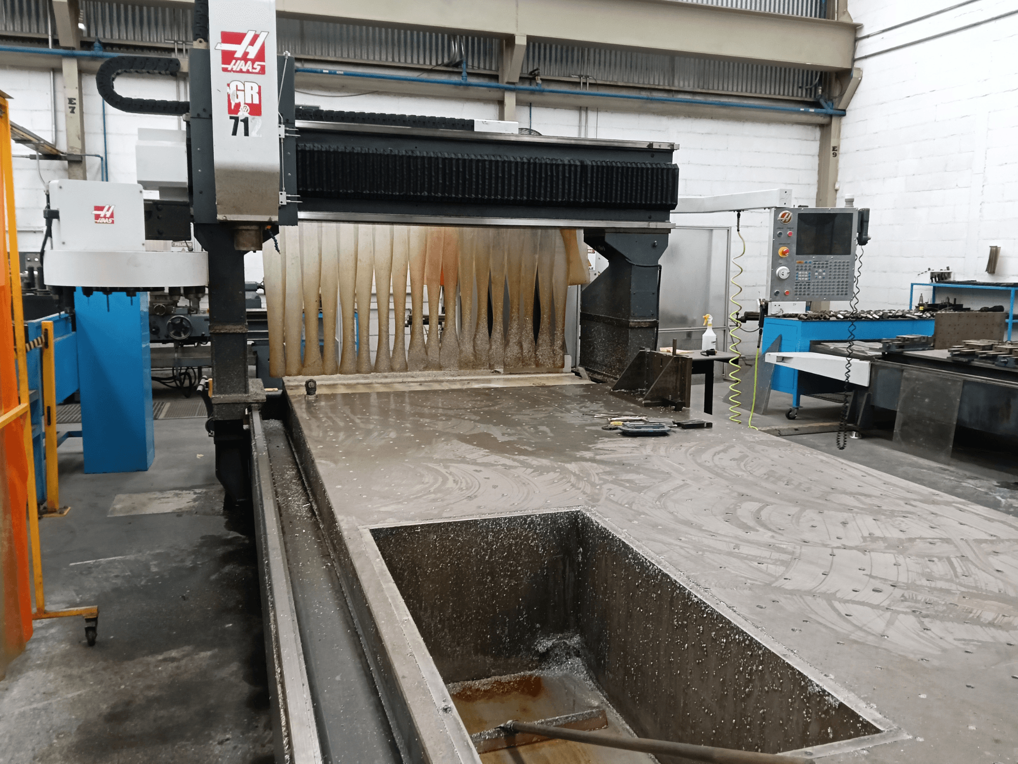 Portfräsmaskinen HAAS GR-712 sedd framifrån, med en våt skäryta och operatörens kontrollpanel.