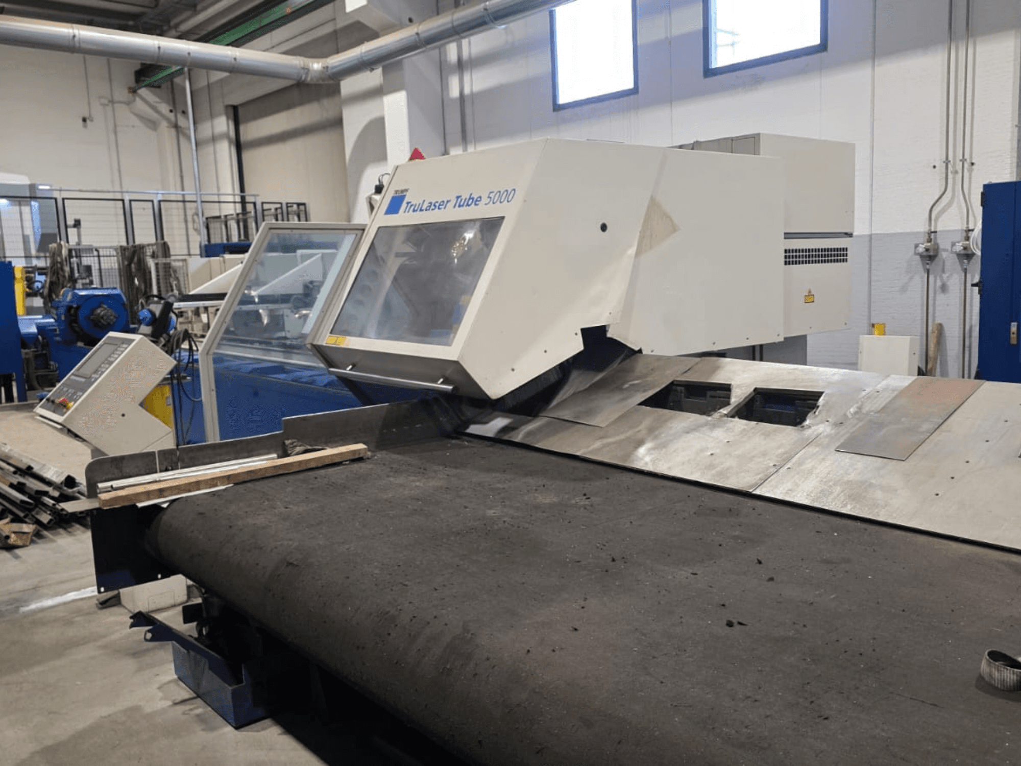 Rörskärmaskinen TRUMPF LASERTUBE 5000, sedd framifrån, med skärområdet och kontrollpanelen i förgrunden.