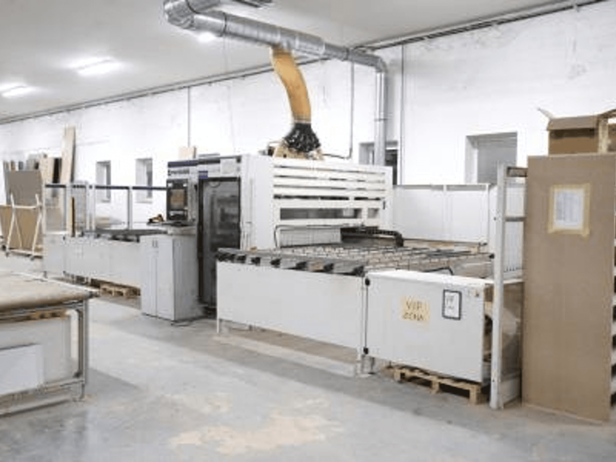 SCM Morbidelli UNIFLEX HP CNC-maskin för träbearbetning i en verkstad, framifrån, med kontrollpanel och matningssystem.