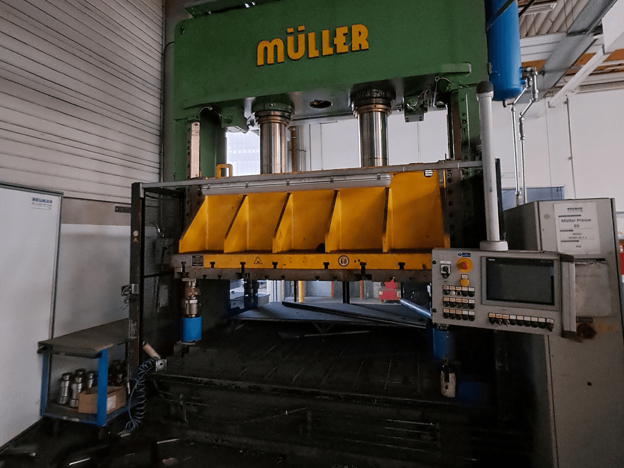 Framifrån sett på en Müller SE 300-25.1.1 metallpress, med gula presskomponenter och en kontrollpanel på sidan.