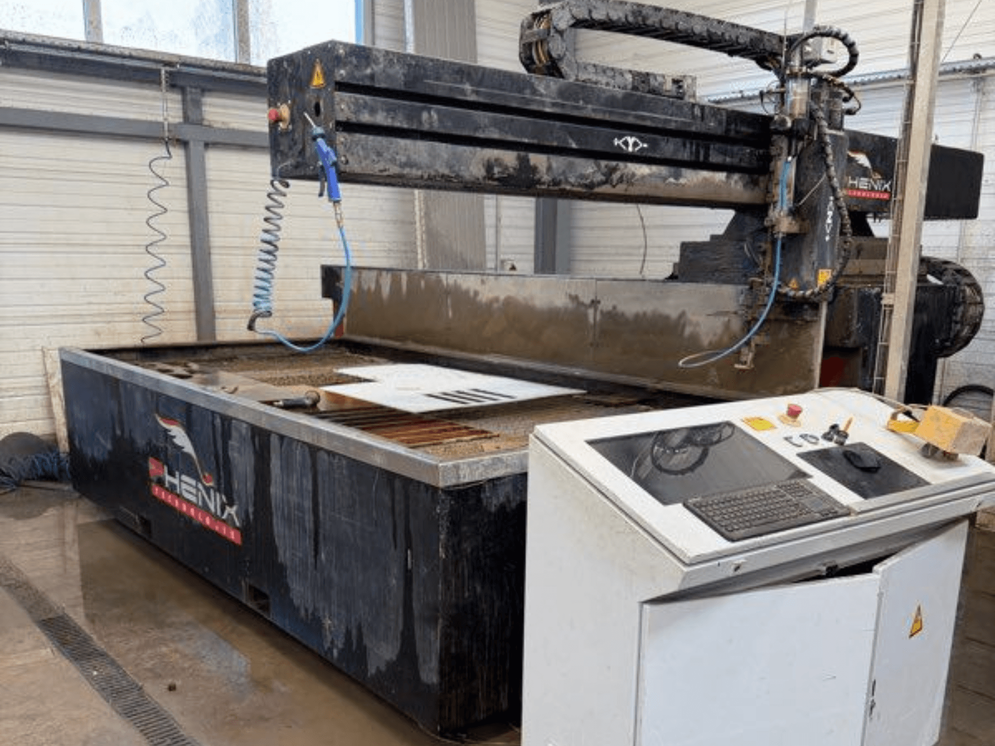 PHENIX MD JET 1530 vattenskärningsmaskin, frontvy som visar kontrollpanelen och skärområdet med synlig vattentank.