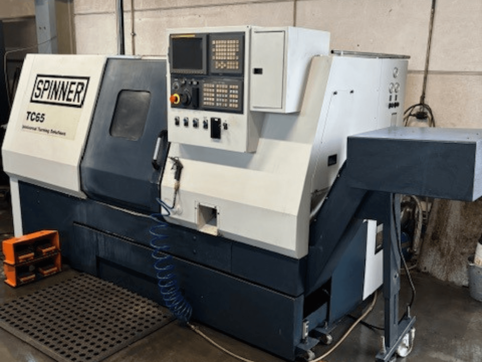 Spinner TC65 industriell svarv, framifrån, med kontrollpanel, tryckluftsledning och förvaringsutrymme för verktyg.