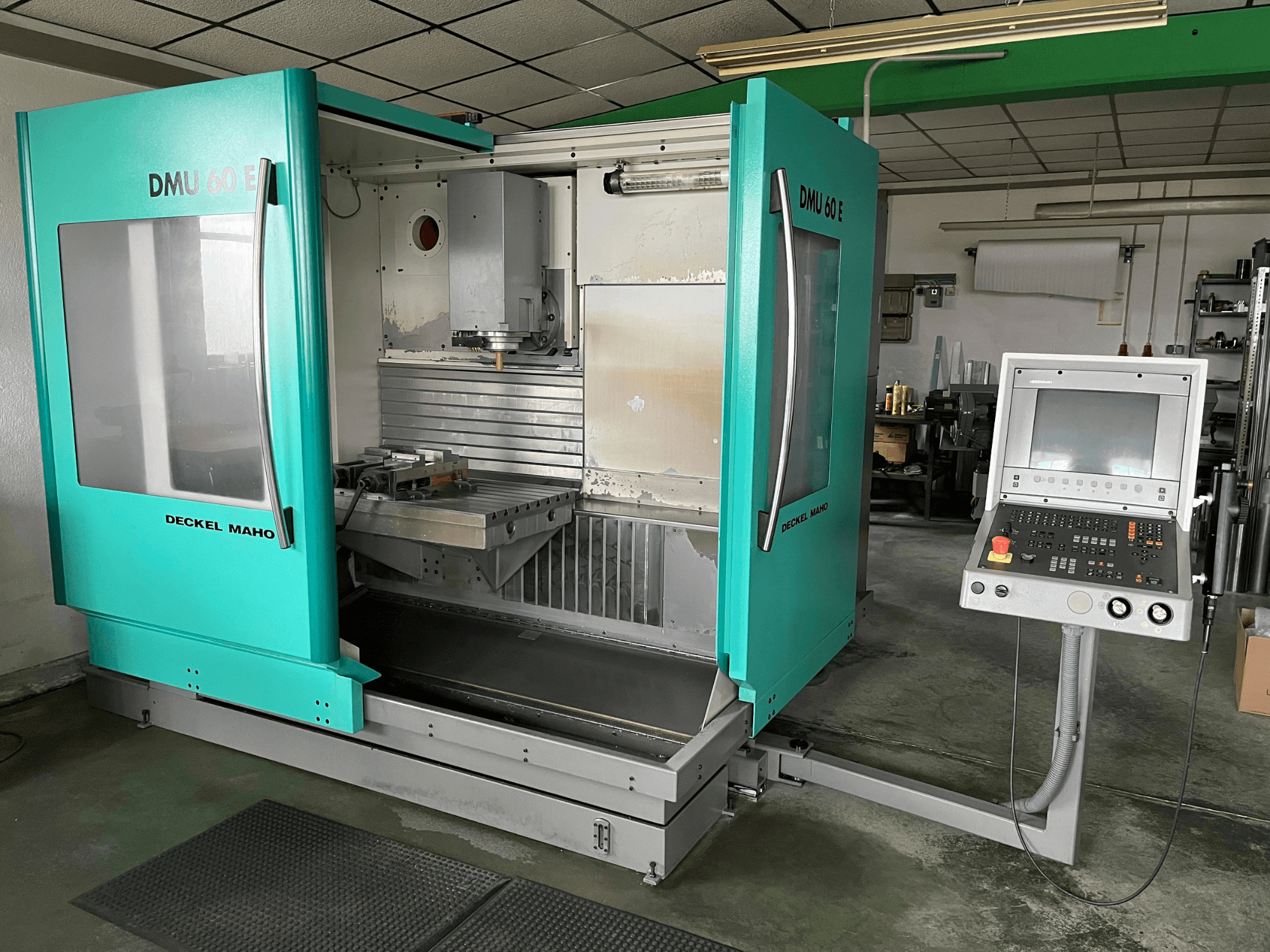 DECKEL DMU 60 E vertikal fleroperationsmaskin framifrån, med kontrollpanel och spindelhuvud för precisionsbearbetning.