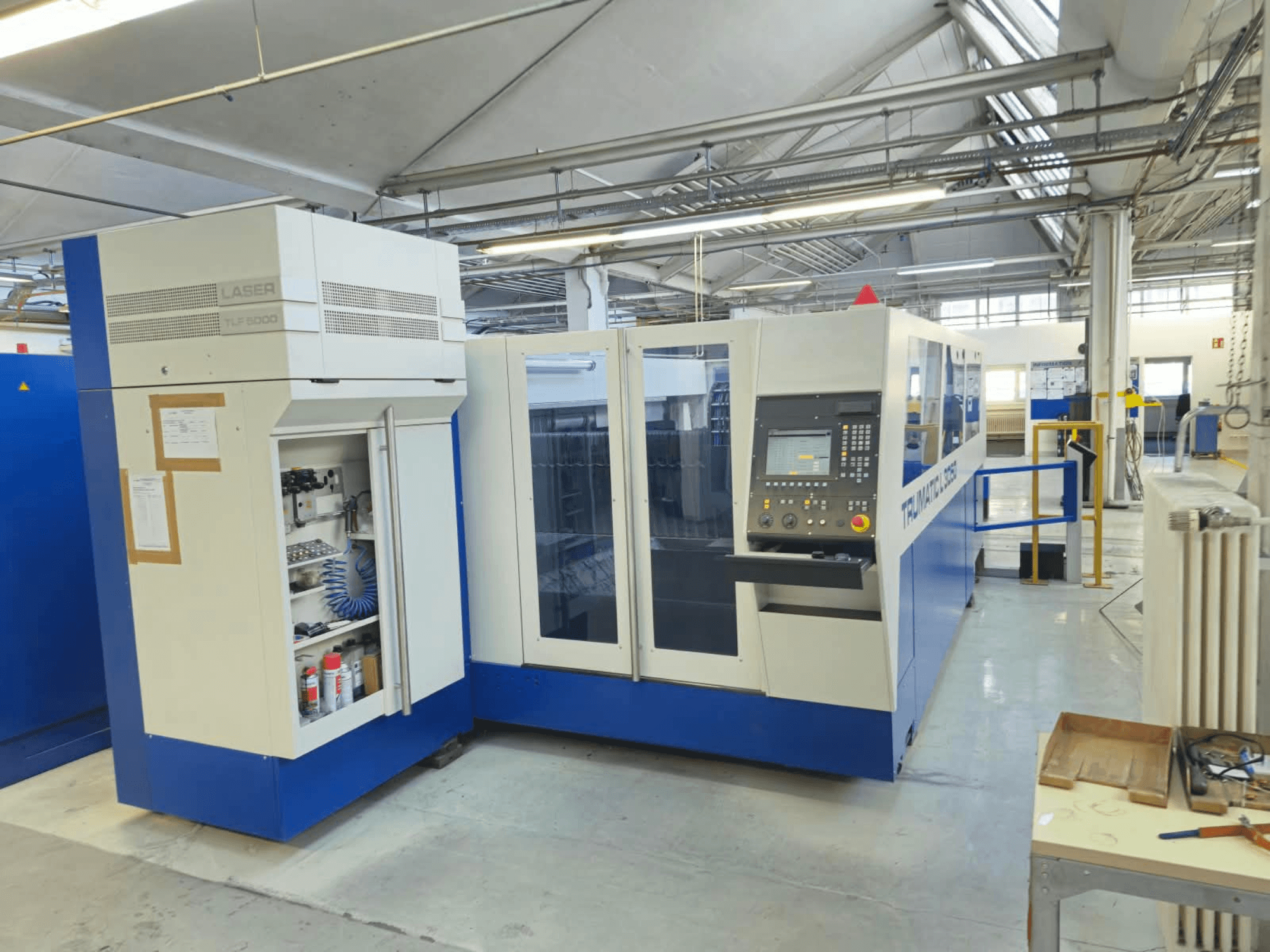 TRUMPF TruLaser L3050 CO₂-laserskärmaskin, framifrån, med kontrollpanel och underhållslucka, i fabriksmiljö.