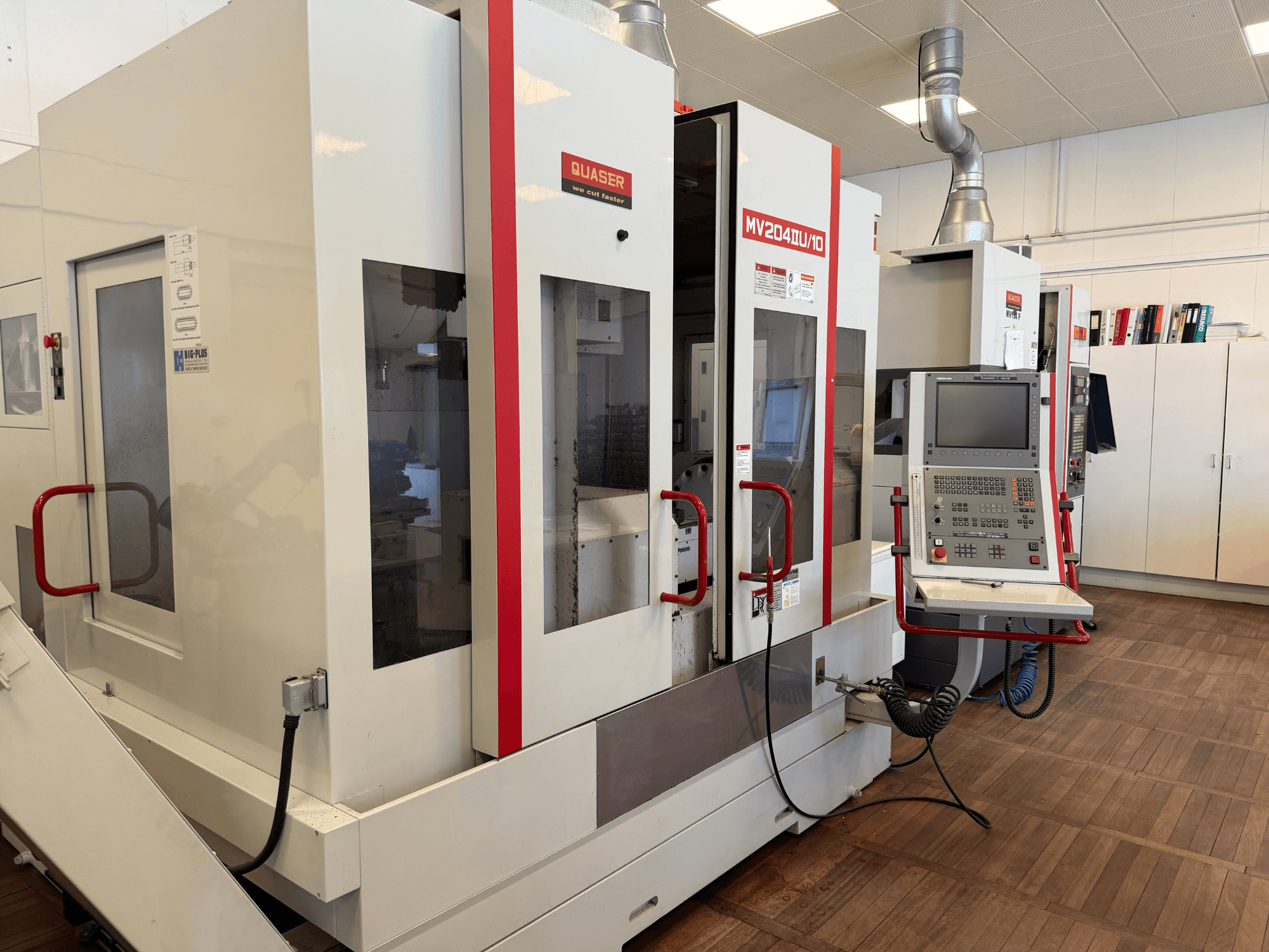 Frontvy av en Quaser MV204U/10 Universal Machining Centre, som visar kontrollpanelen och installationen med två maskiner.