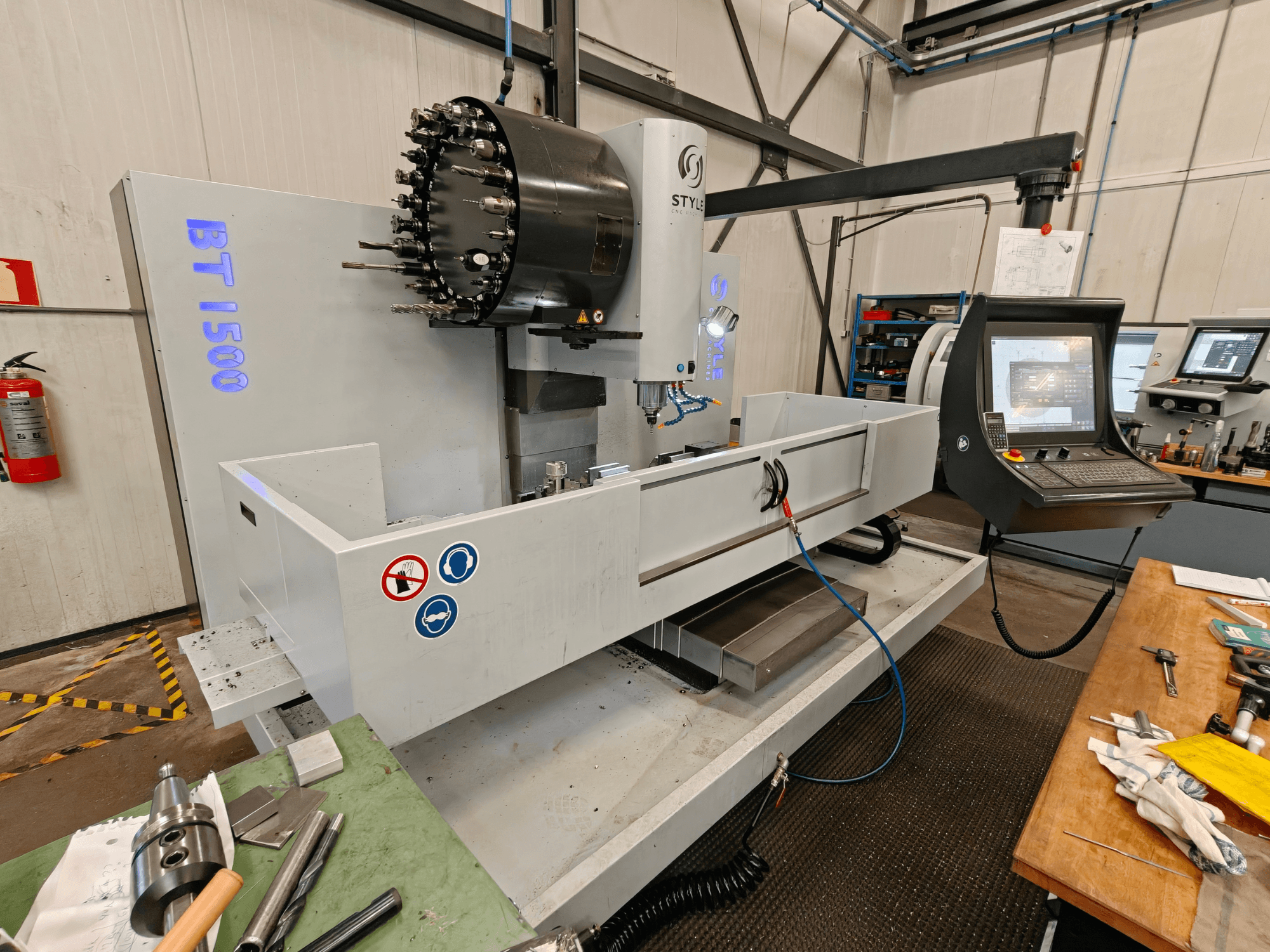 Vertikal fleroperationsmaskin STYLE BT 1500 i en verkstad, med kontrollpanel, verktygshållare och arbetsområde.