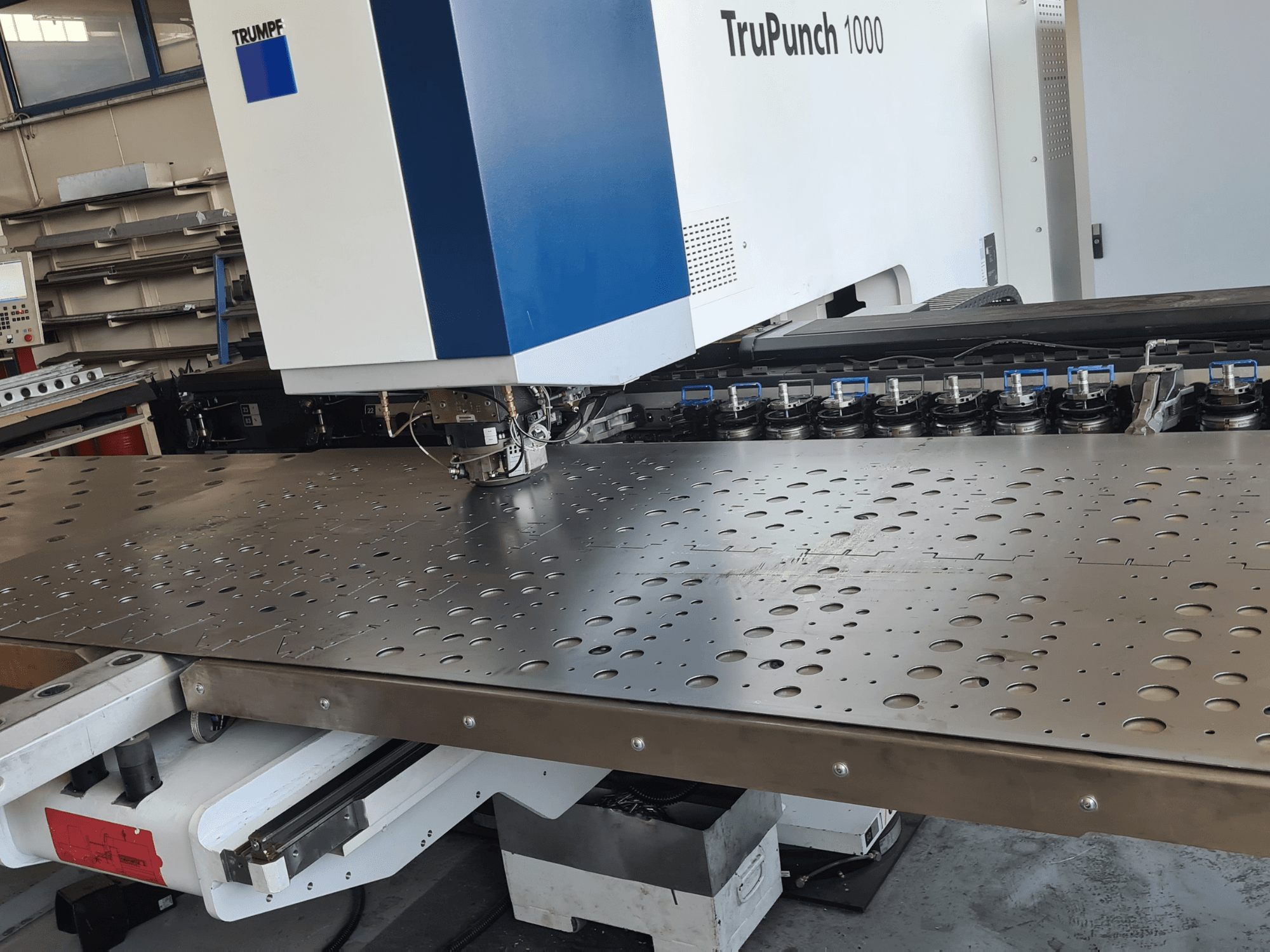 CNC-stansmaskin TRUMPF TruPunch 1000, framifrån, med en perforerad plåt och verktygsinställning.