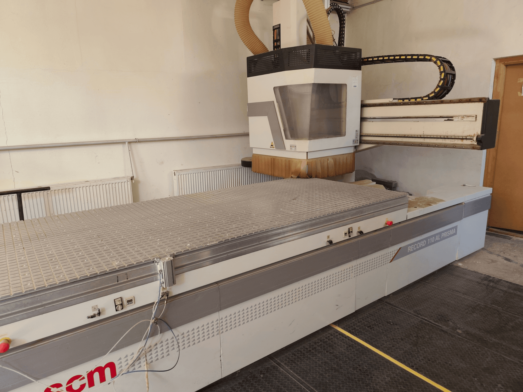 CNC-bearbetningscenter för trä SCM Record 110AL, sidovy som visar det stora arbetsbordet och fräshuvudet.