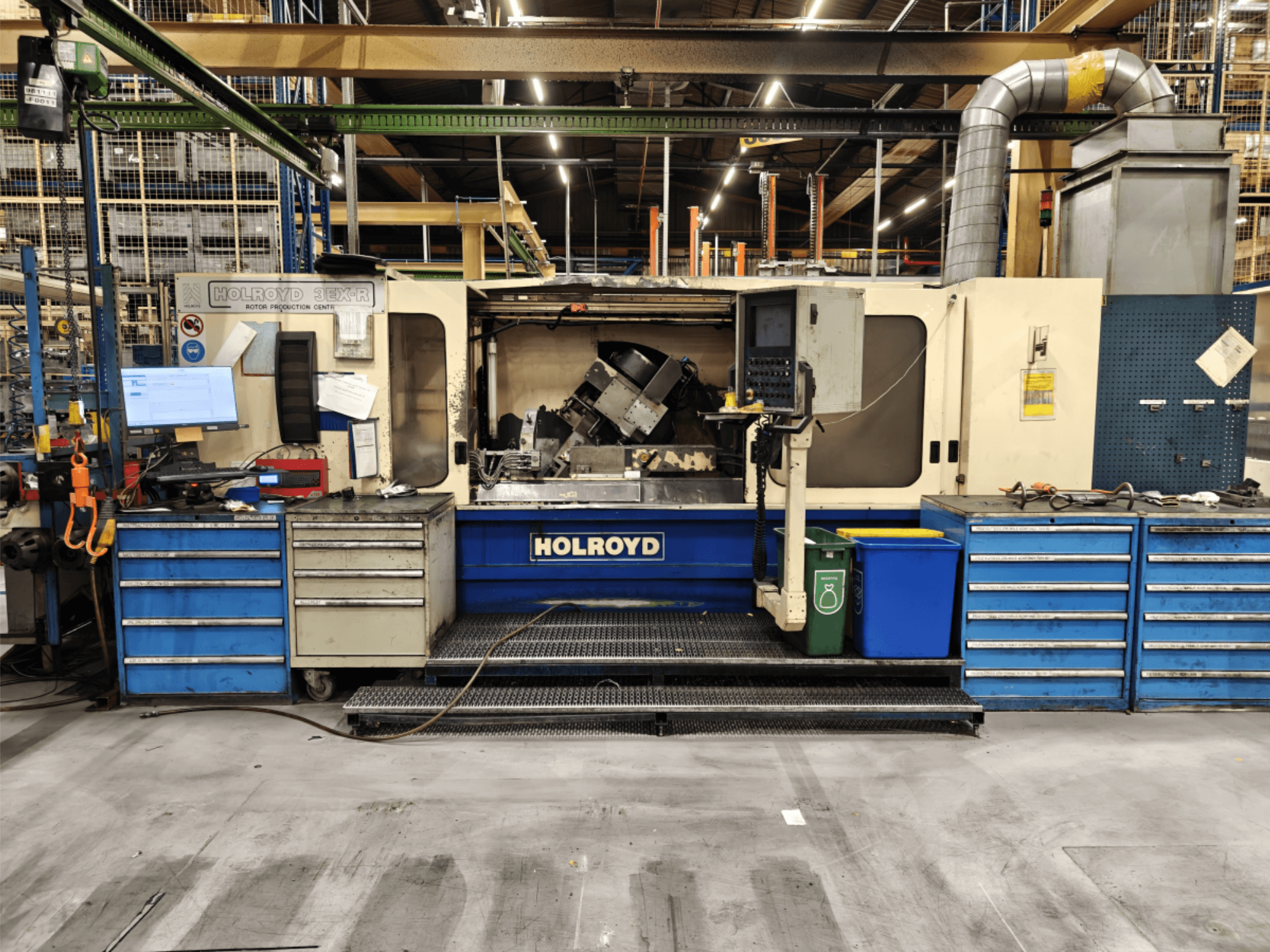 Holroyd 3EX-R verktygsmaskin i en verkstad, vy framifrån, med kontrollpanel, verktygsförvaring och arbetsyta inuti.