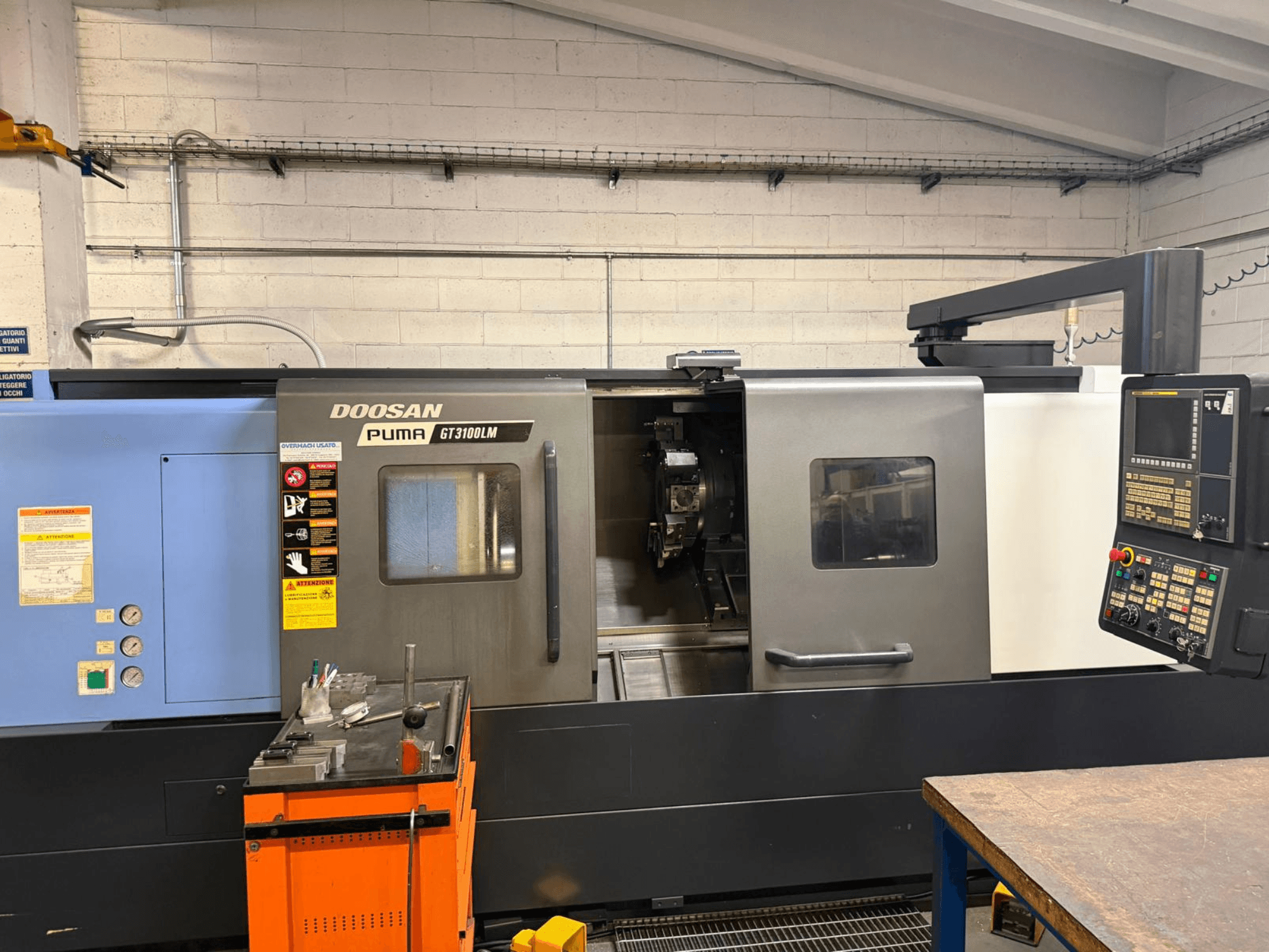 Frontvy av den horisontella svarven DOOSAN PUMA GT3100LM, som visar kontrollpanelen och arbetsområdet med verktyg.