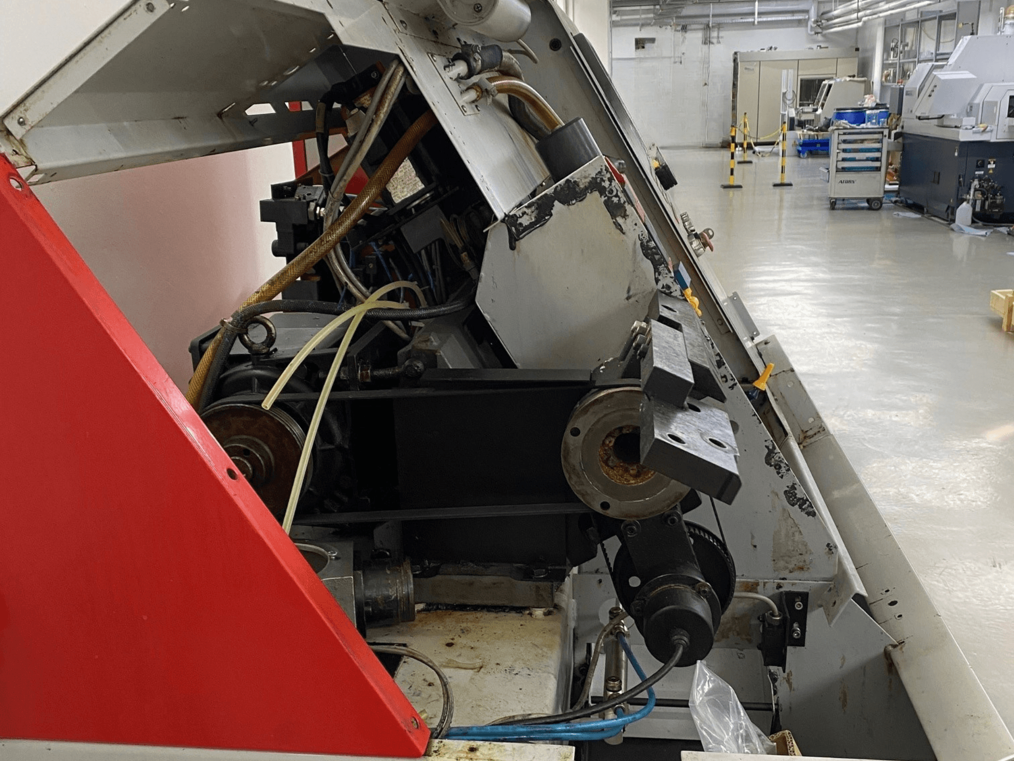 EMCO Emcoturn 325 horisontell svarv, sidovy som visar drivkomponenter och hydraulik i industriell miljö.