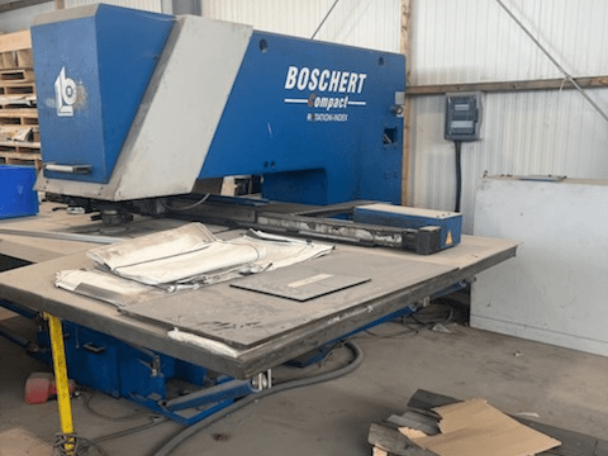 En BOSCHERT COMPACT 1000 CNC-stansmaskin i en verkstad, sedd framifrån med plåtark på bordet.