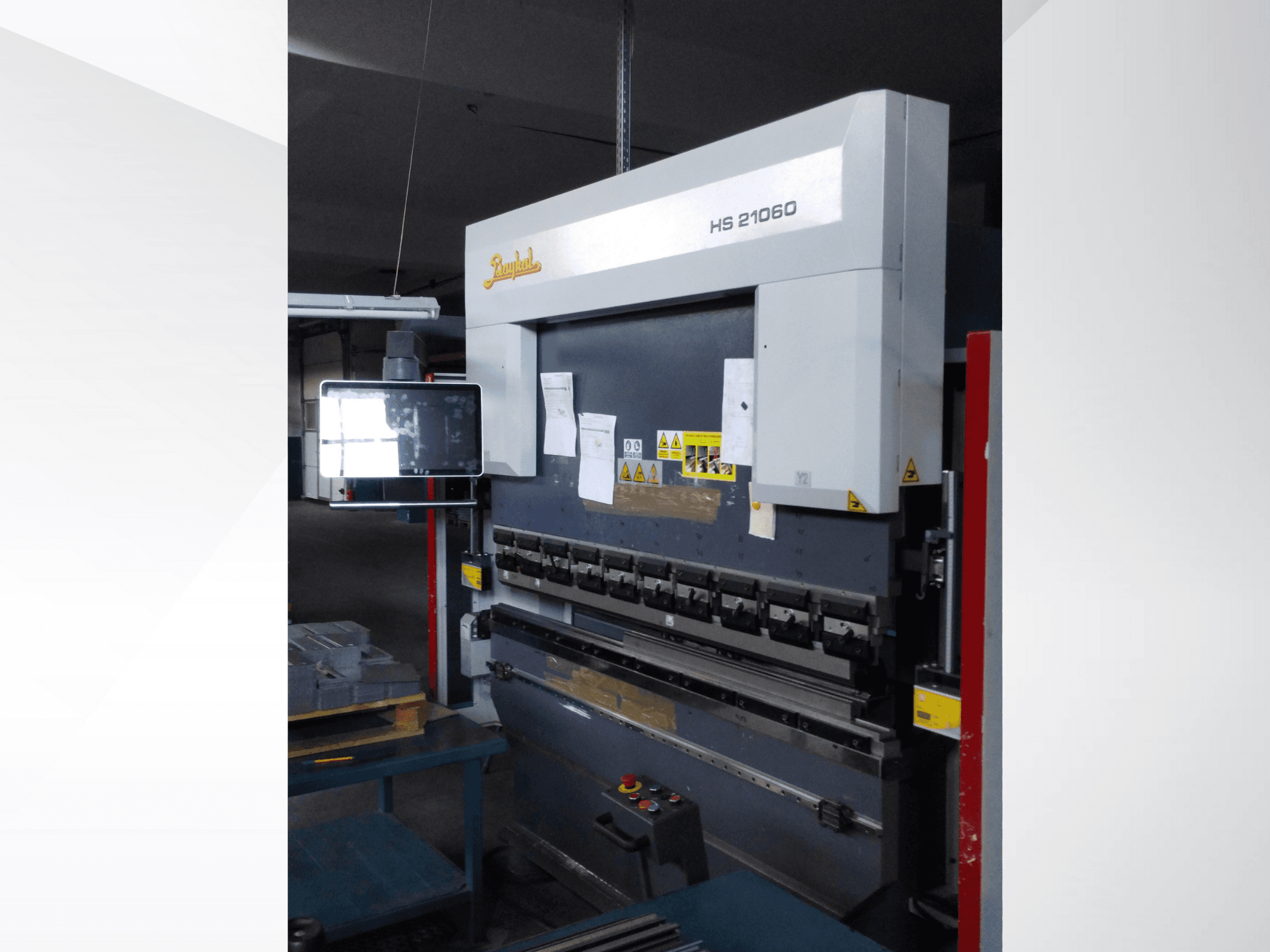 Beyeler HS 21060 kantpress, framifrån, visar reglage, en displayskärm och varningsetiketter i en verkstadsmiljö.