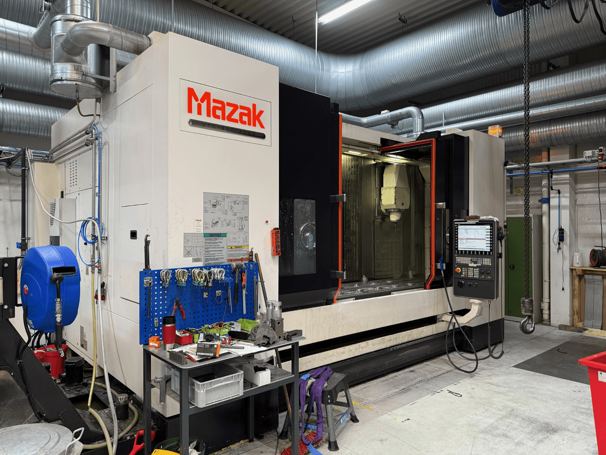 Mazak CNC-maskin framifrån, med reglage, verktyg och arbetsyta i en bearbetningsmiljö.