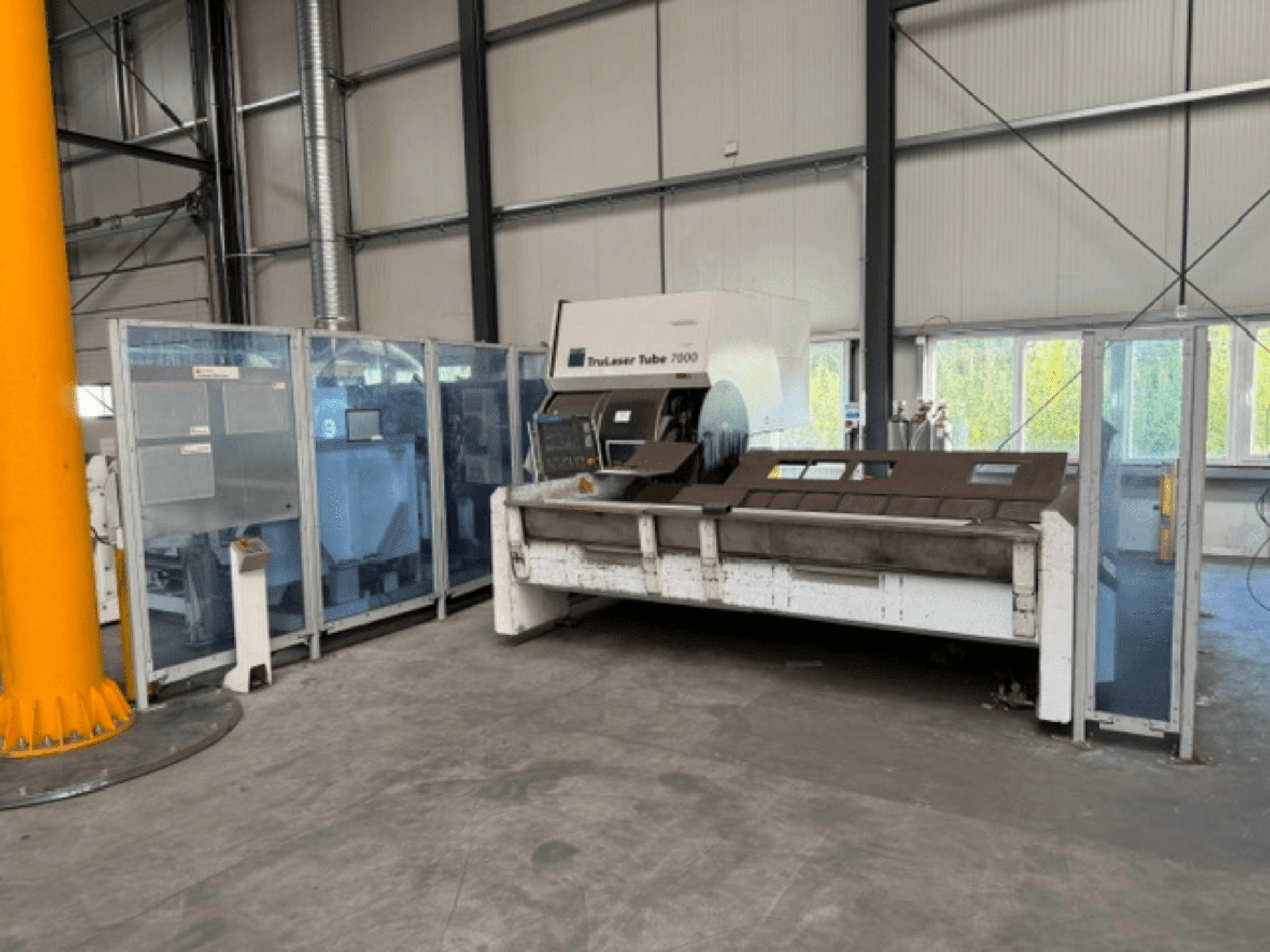 TruLaser Tube 7000 från TRUMPF, framifrånvy av en rörskärmaskin i en väl upplyst industrimiljö där man ser manöverpanelerna.