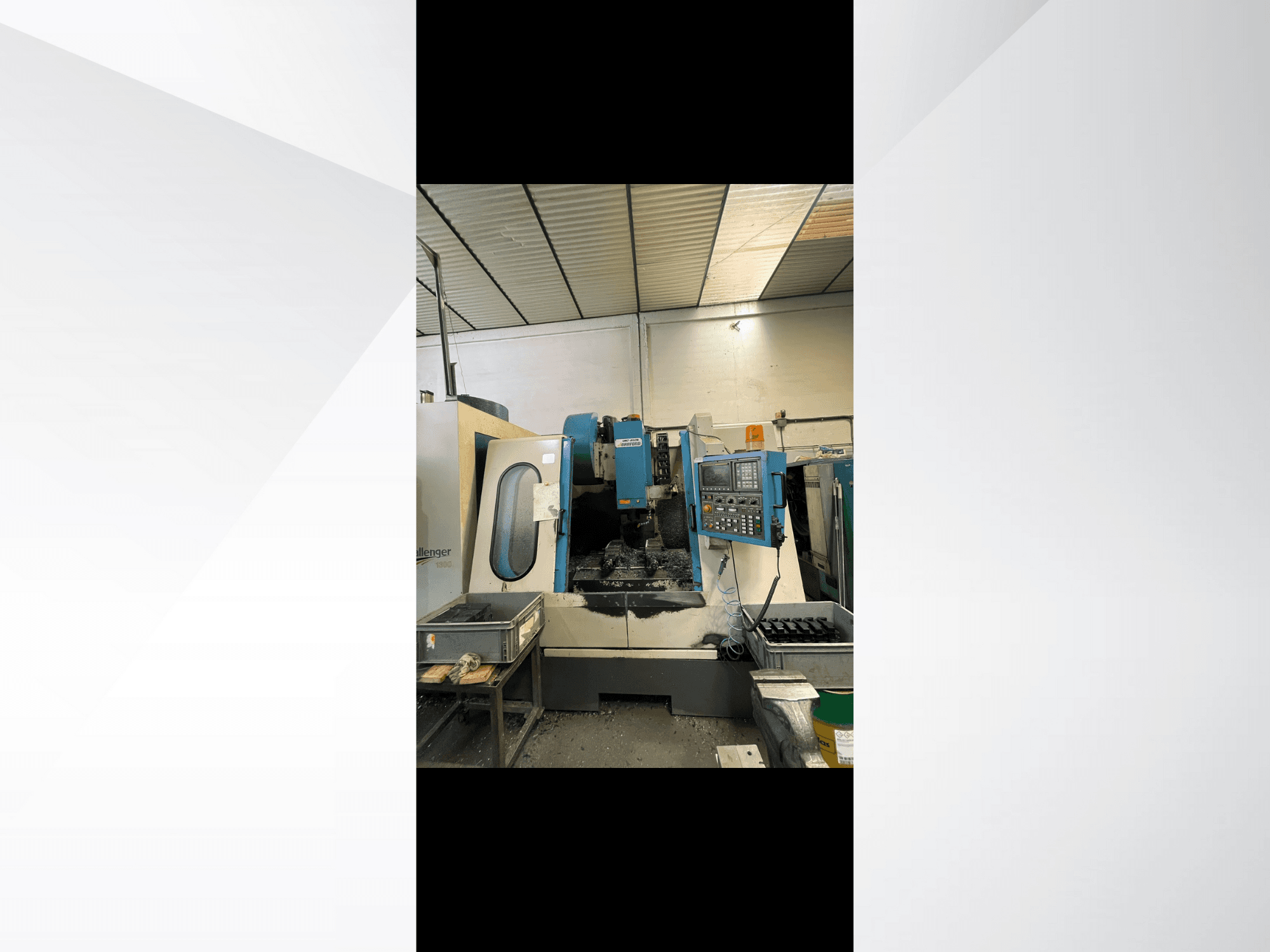 CNC-maskin, modell Challenger 1500, sidovy som visar kontrollpanel och arbetsyta med metallspån.