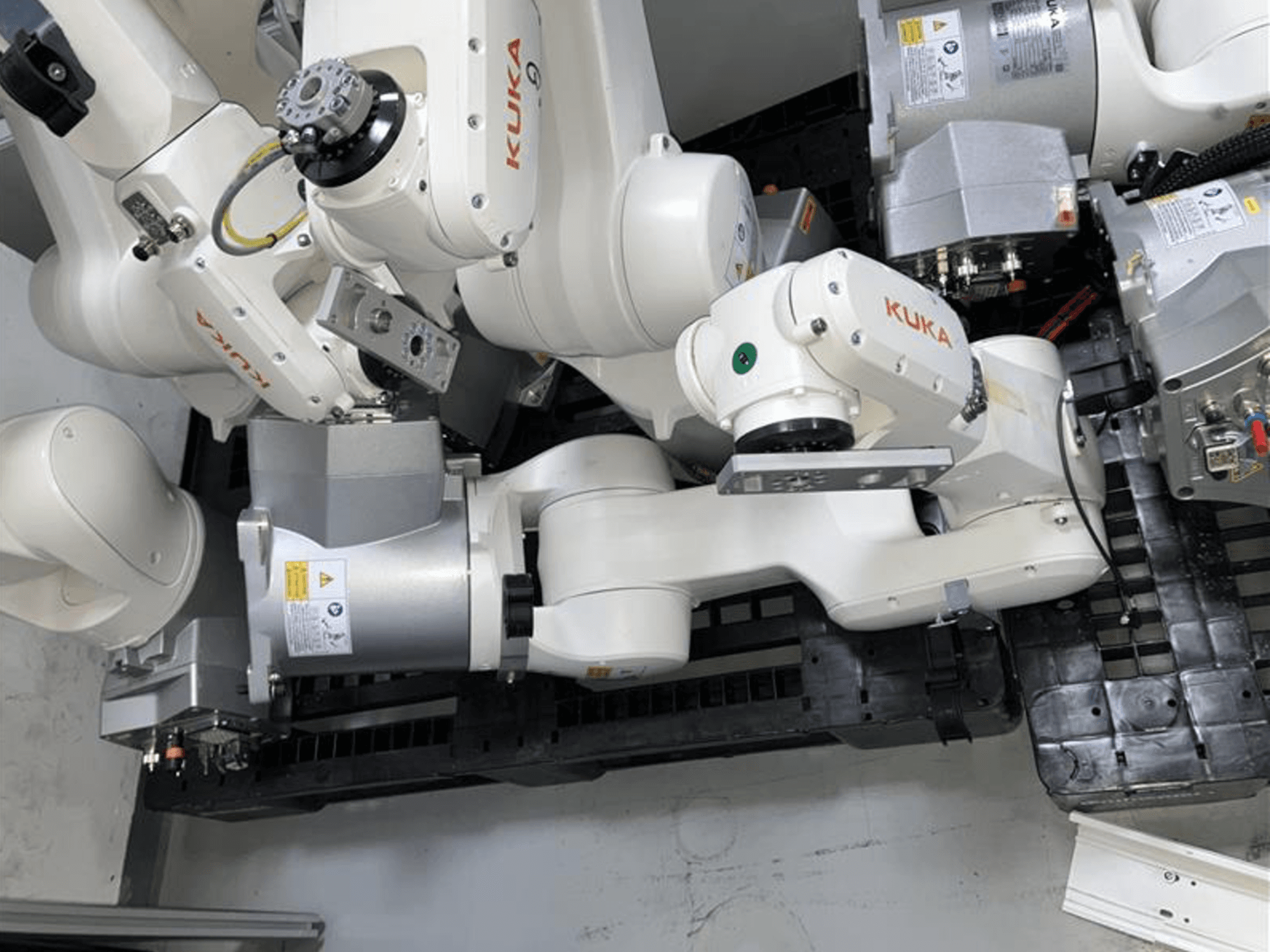 KUKA KR 6 R900 CR robotarm i vy uppifrån, med flera leder och motorer, monterad på en svart bas med kablar.