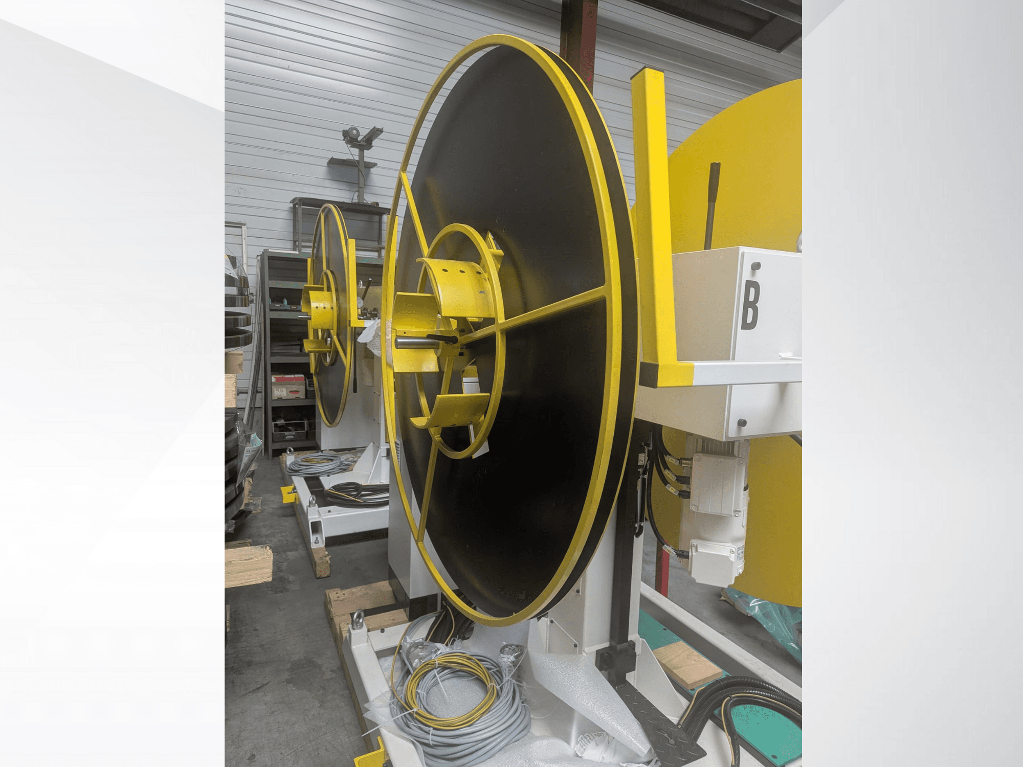 Stor industrispole, modell XYZ, med svart yta och gula accenter, sedd från sidan, med elektriska anslutningar.