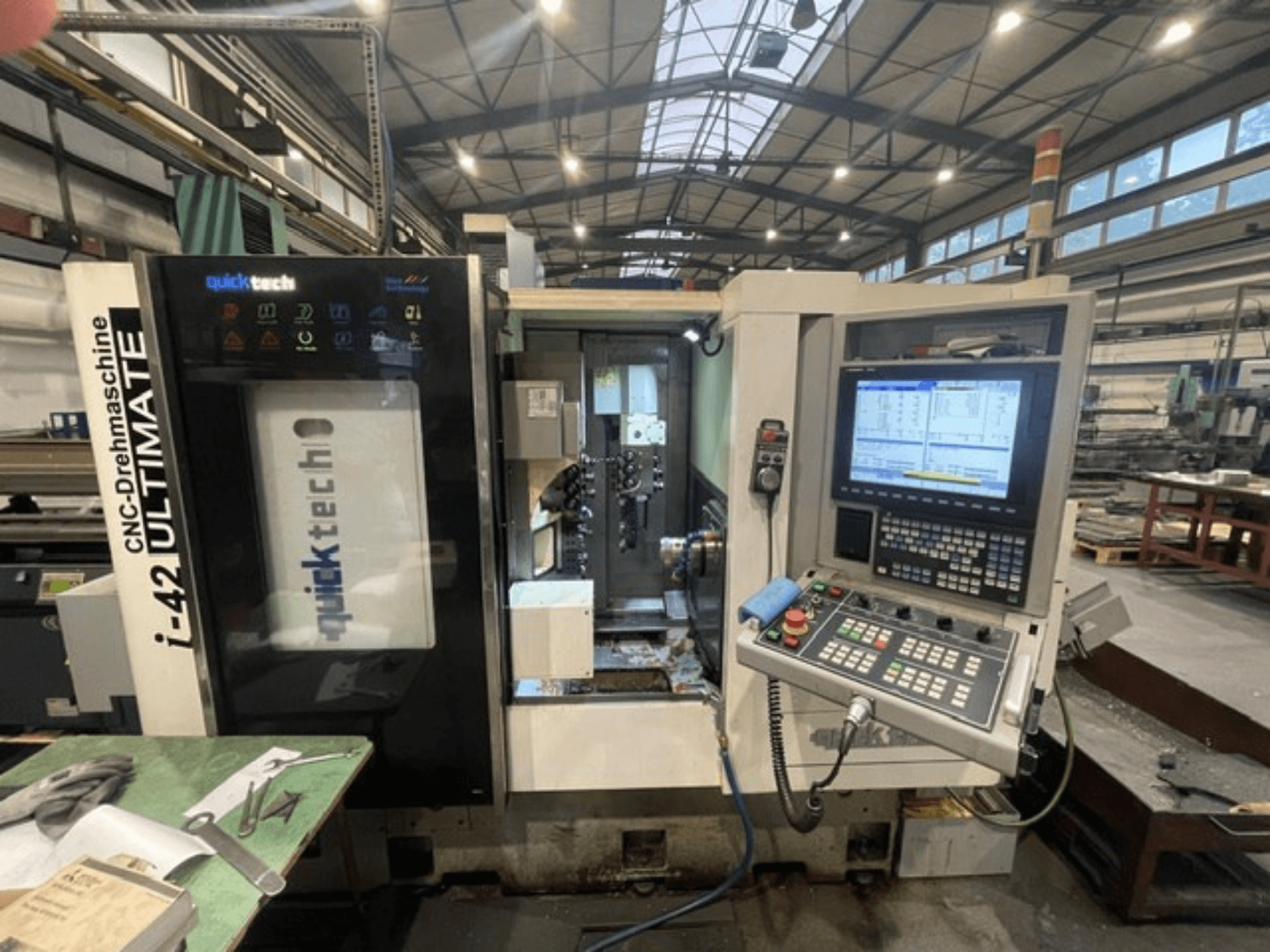 Quick-Tech I-42U svarv av schweizisk typ, framifrån, visar kontrollpanelen och CNC-gränssnittet i en verkstadsmiljö.