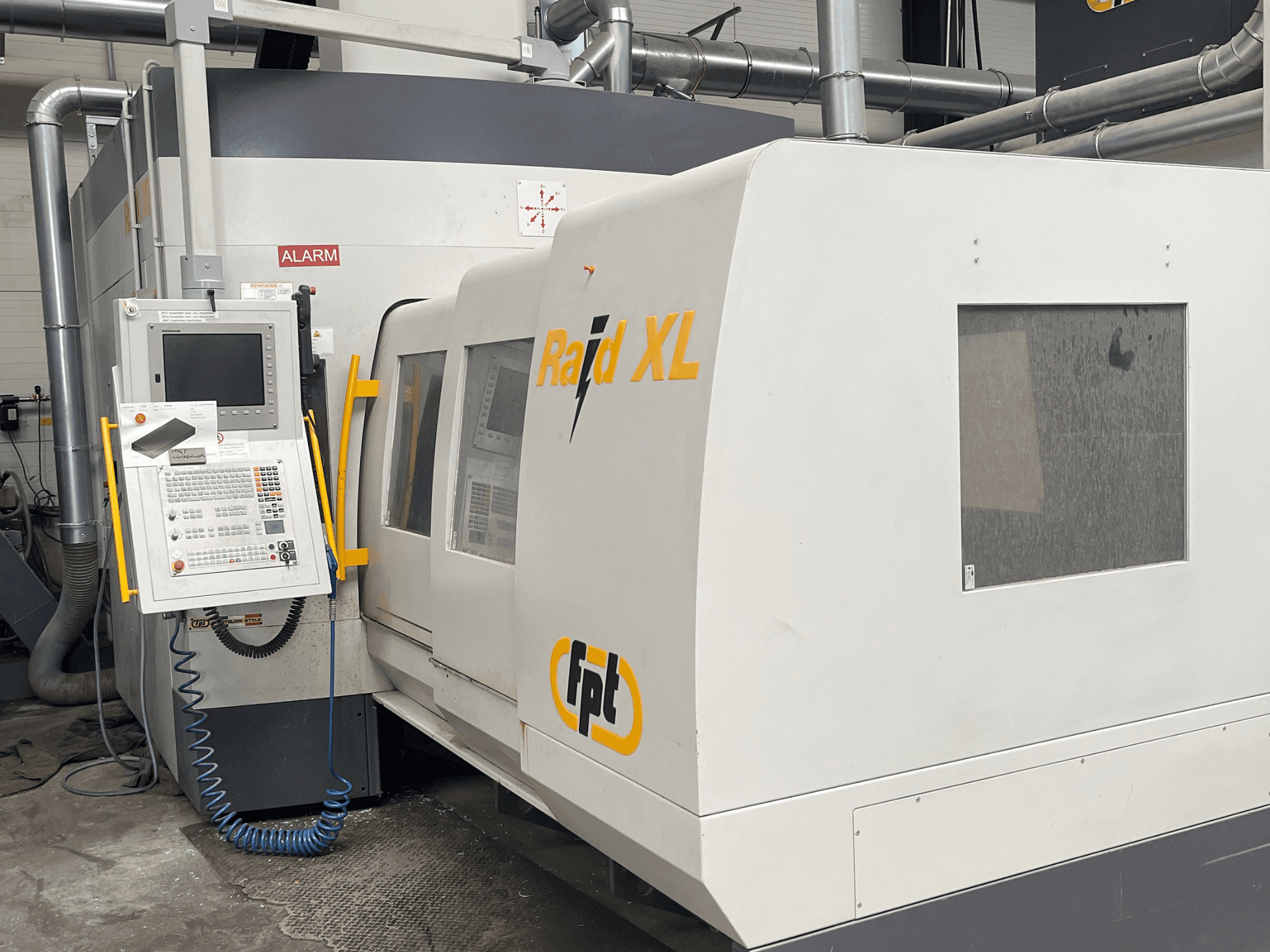Portfräsmaskinen FPT Raid XL sedd framifrån med kontrollpanelen, vilket visar dess industriella design och driftsfunktioner.