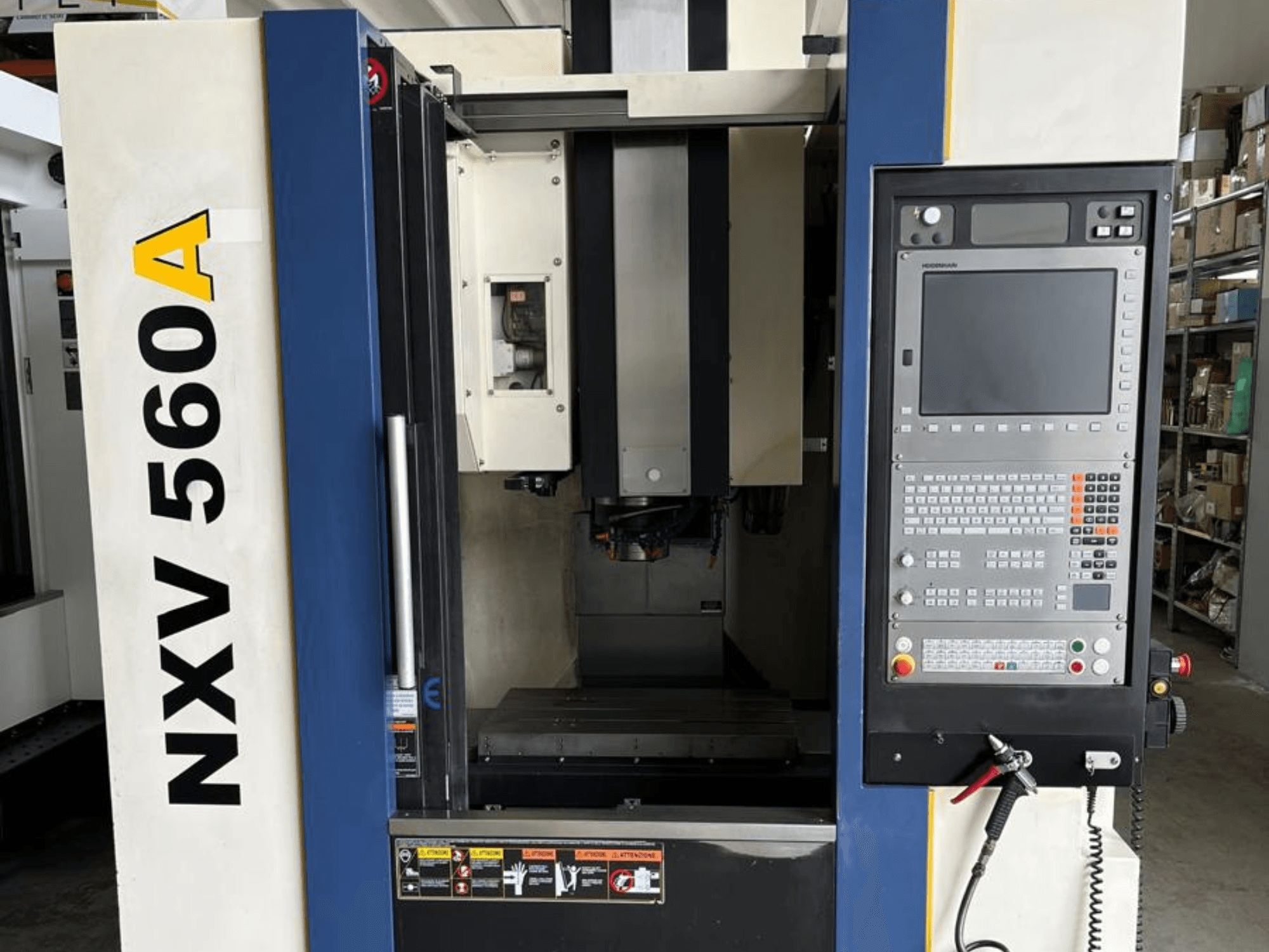 CNC-maskinen NXV 560A sedd framifrån, med en kontrollpanel med knappar och en digital display.