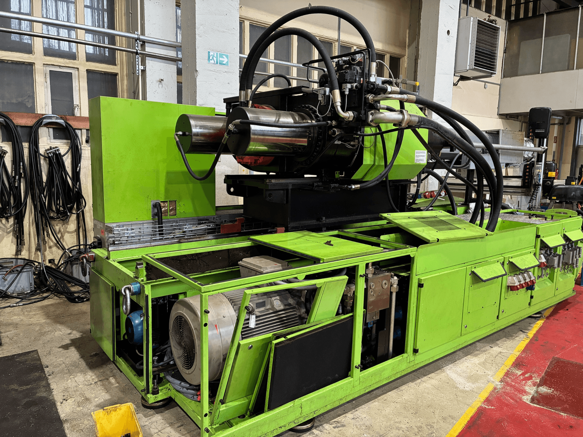 Grön industrimaskin med hydraulsystem, framifrån, med motor och olika kontrollpaneler.