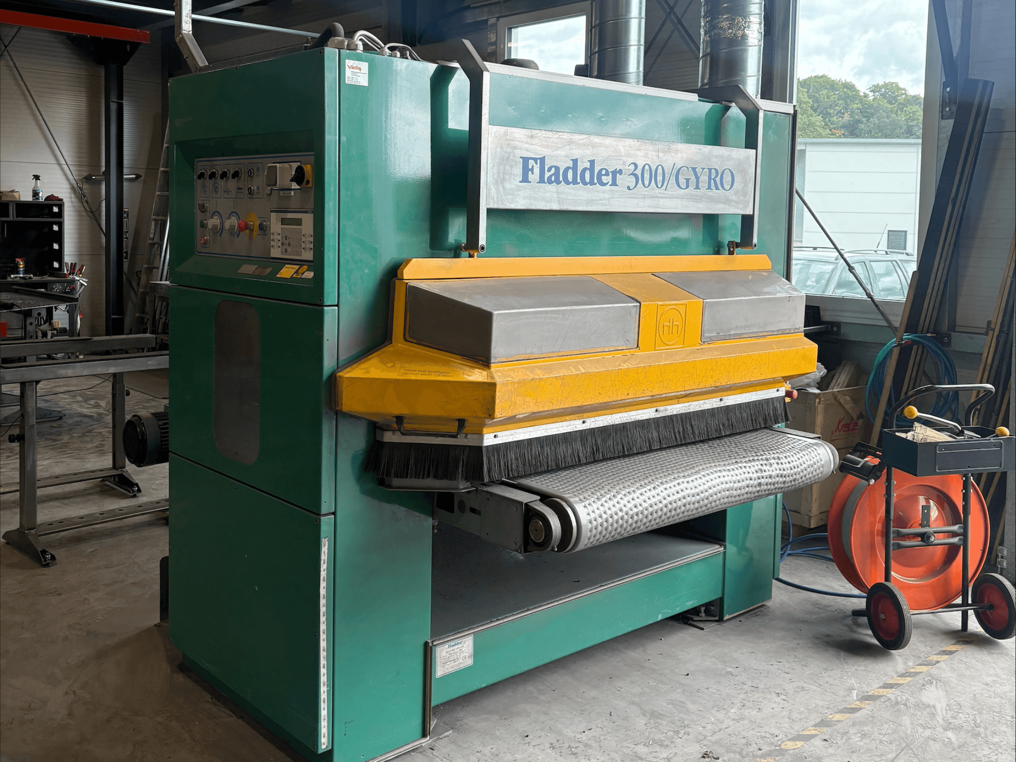 Fladder 300/GYRO industriell slipmaskin i grönt och gult, framifrån, med kontrollpanel och sliptrumma.