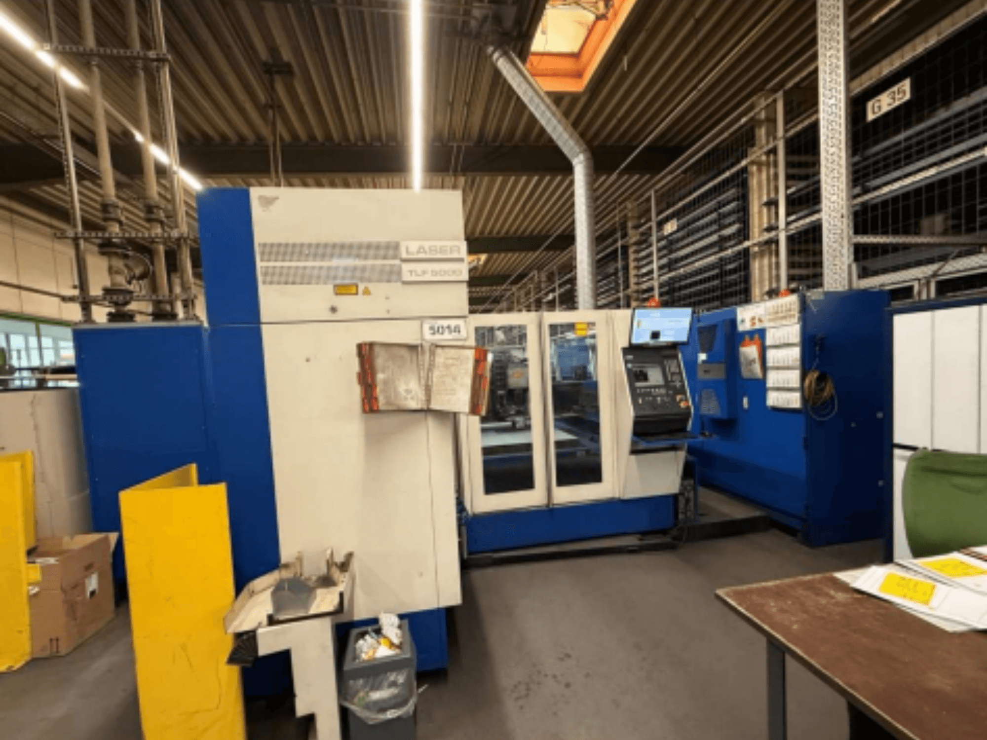 Frontvy av TRUMPF Trumatic L 3050 CO2-laserskärmaskin, som visar kontrollpanelen och driftsfunktionerna i en verkstad.