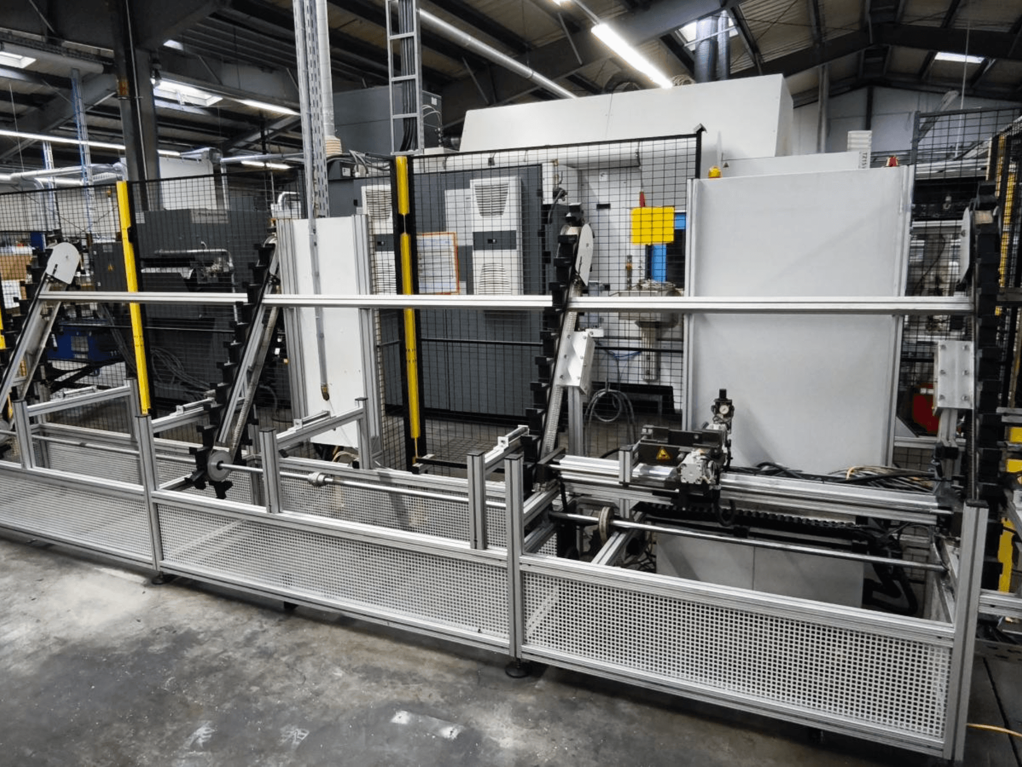 LOHMEIER Schräglademagazin arbetsstyckeshanteringssystem i frontvy, som visar metallstrukturen och de integrerade mekaniska komponenterna.