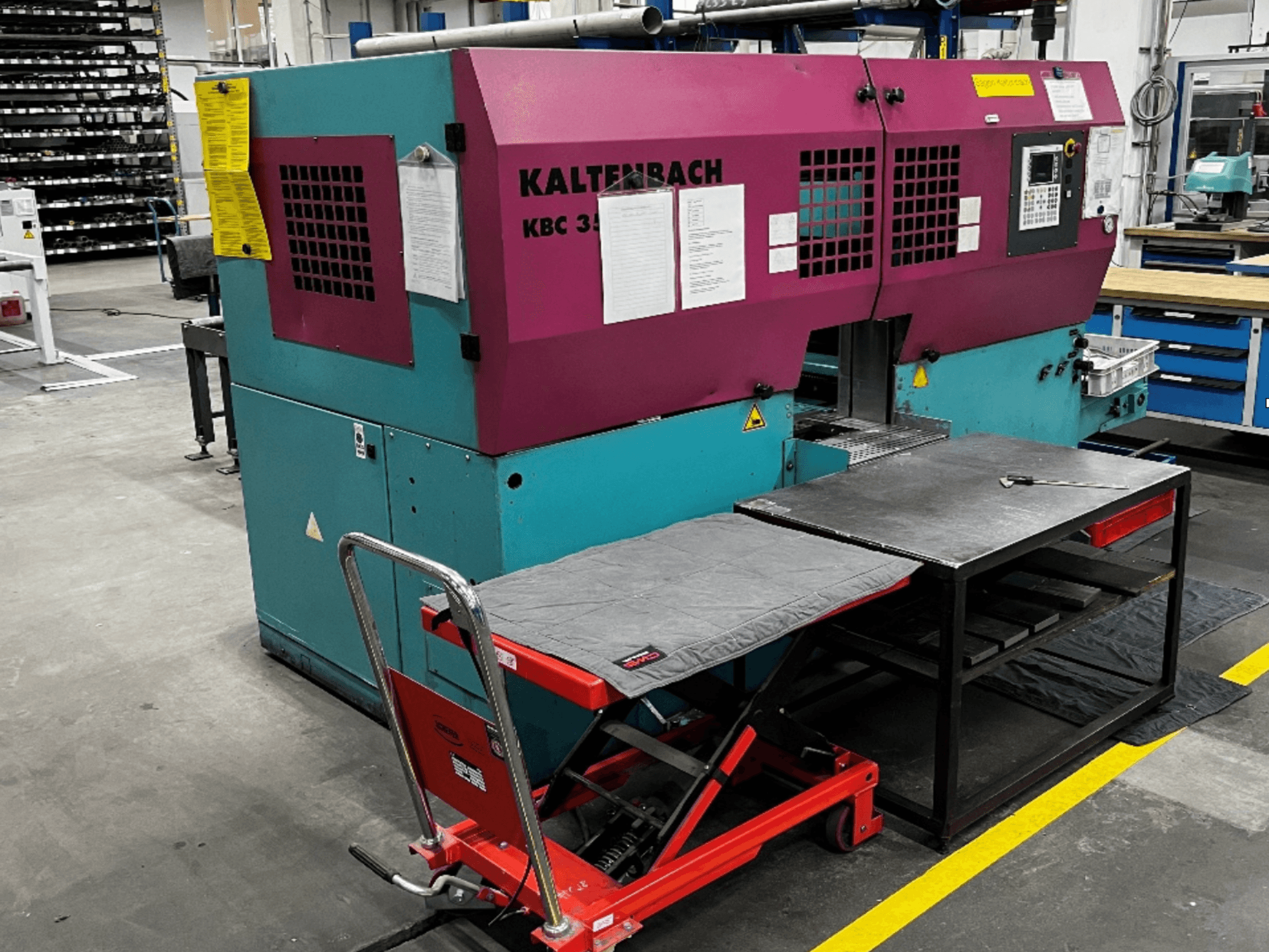 KALTENBACH KBC 350 NA Metallbandsåg framifrån med arbetsbord och röd lyftvagn i verkstadsmiljö.