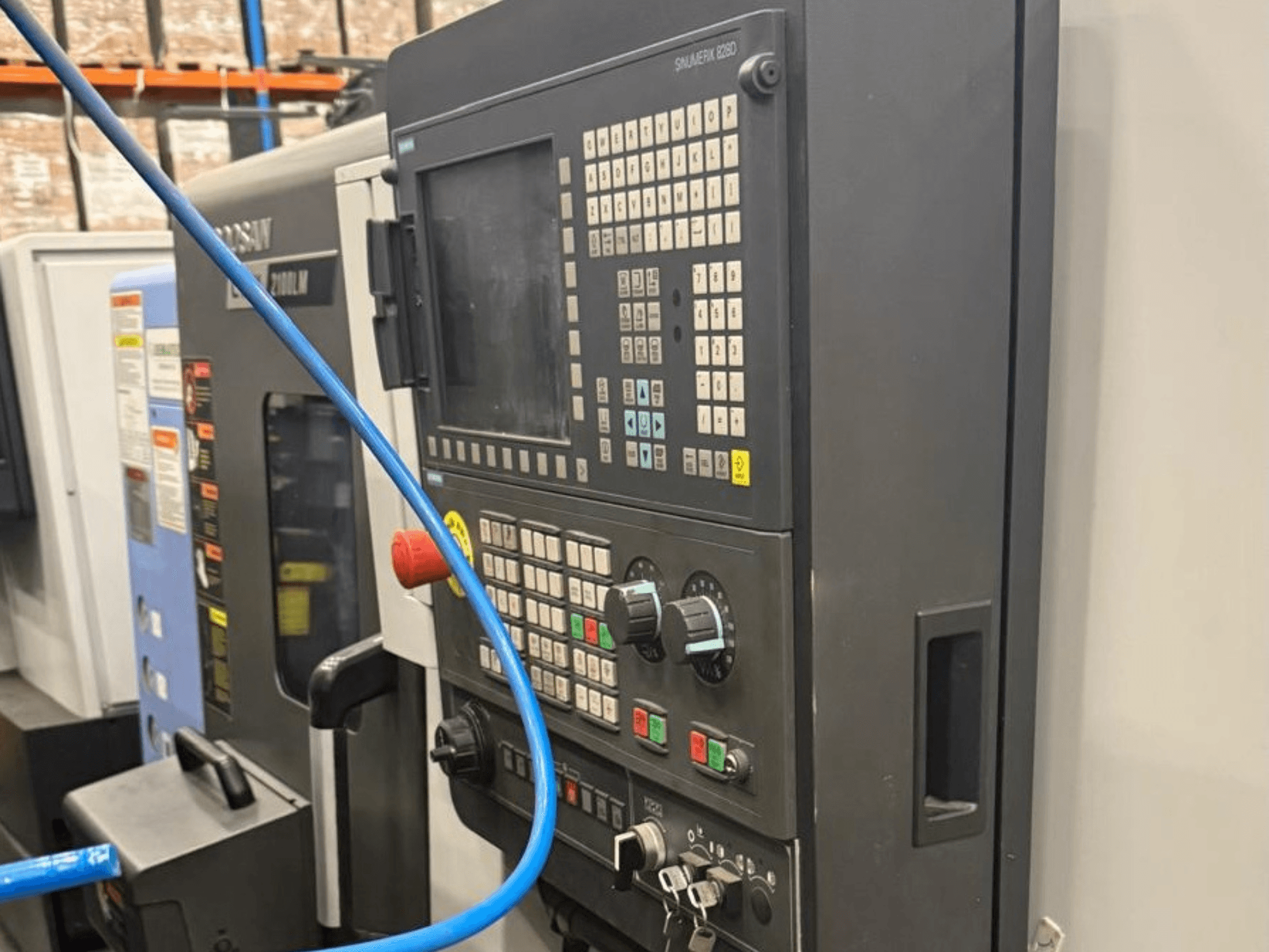 Kontrollpanel på ett bearbetningsverktyg, framifrån, med knappar, vred och en digital display för exakt manövrering.