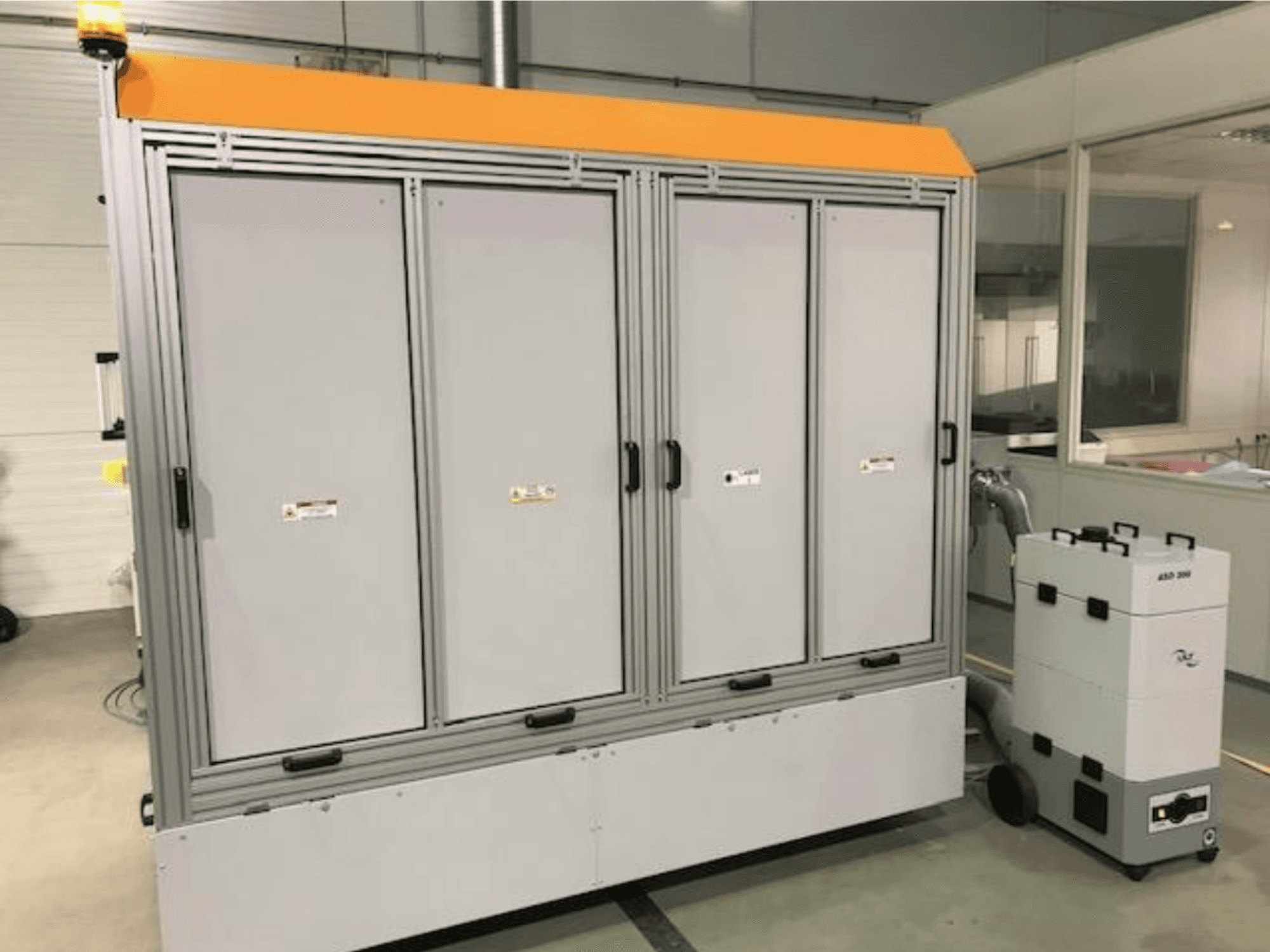 4JET Pearl M fiberlaserskärmaskin, framifrån, med säkerhetslampa, kontrollpanel och ansluten extraktionsenhet synlig.