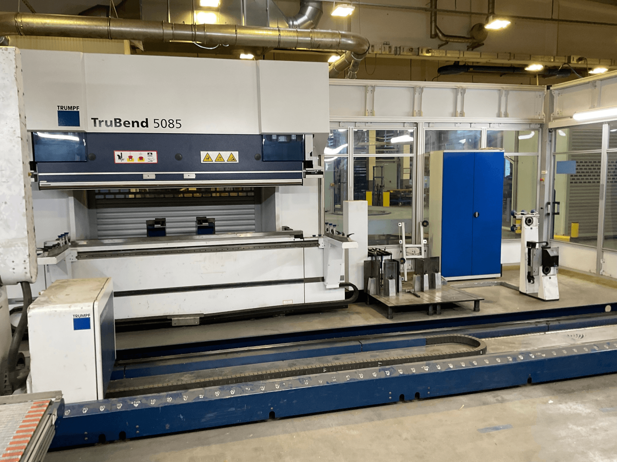 TruBend 5085 från TRUMPF, sidovy av en stor metallbockningsmaskin med kontrollpanel och olika verktyg bredvid.