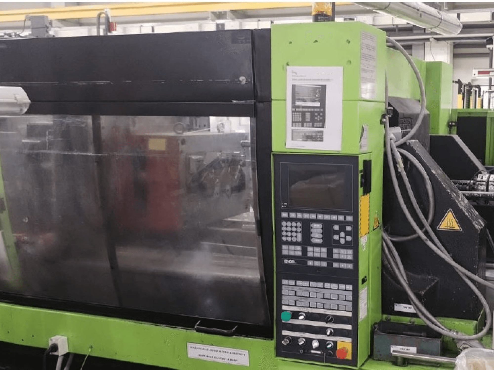 Hydraulisk formsprutningsmaskin av typen Engel ES 1050/275 HL-V, sidovy som visar kontrollpanelen och driftsdetaljer.