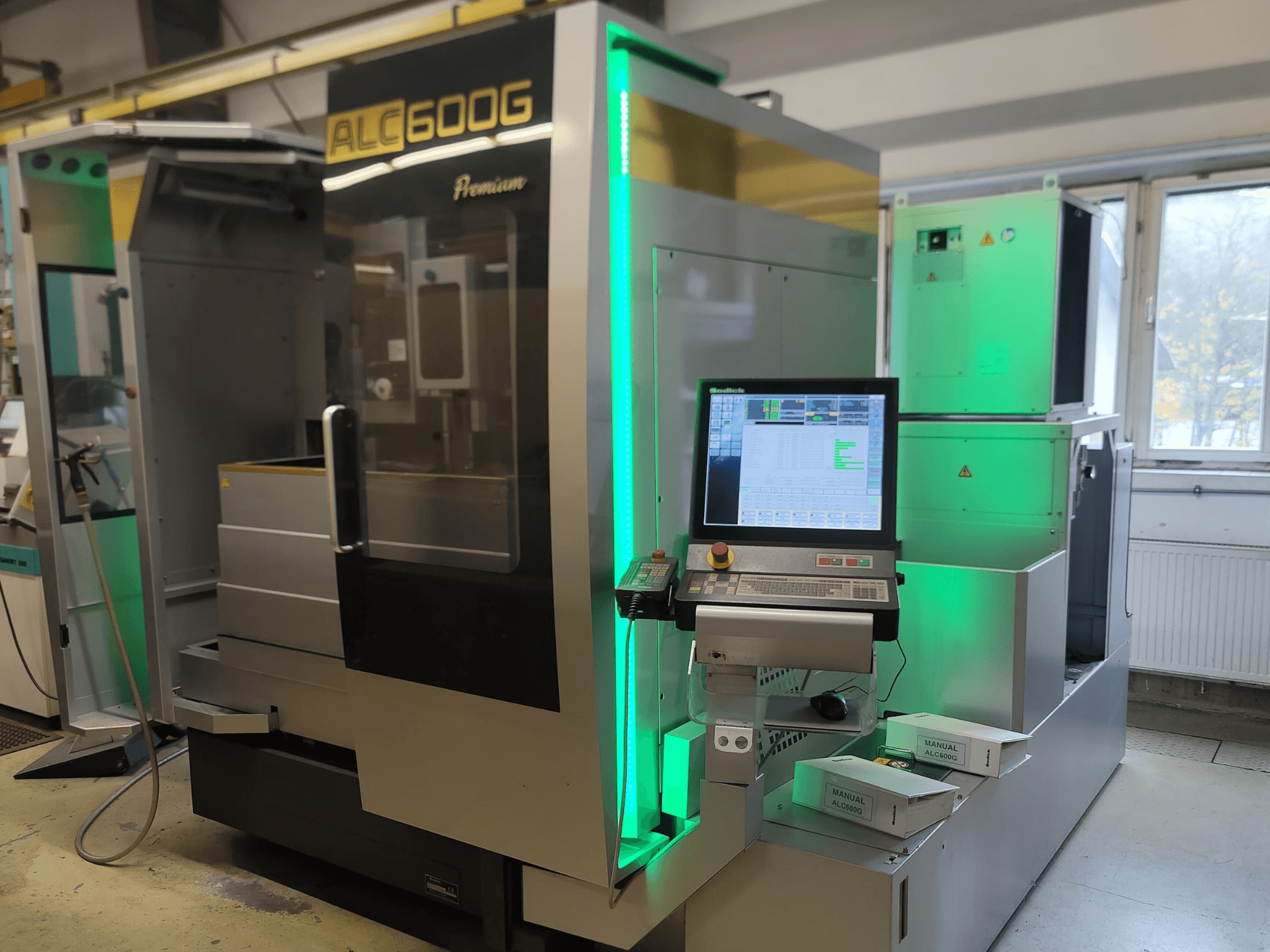 Sodick ALC600G Premium Wire EDM-maskin, framifrån, med kontrollpanel och upplysta yttre detaljer.