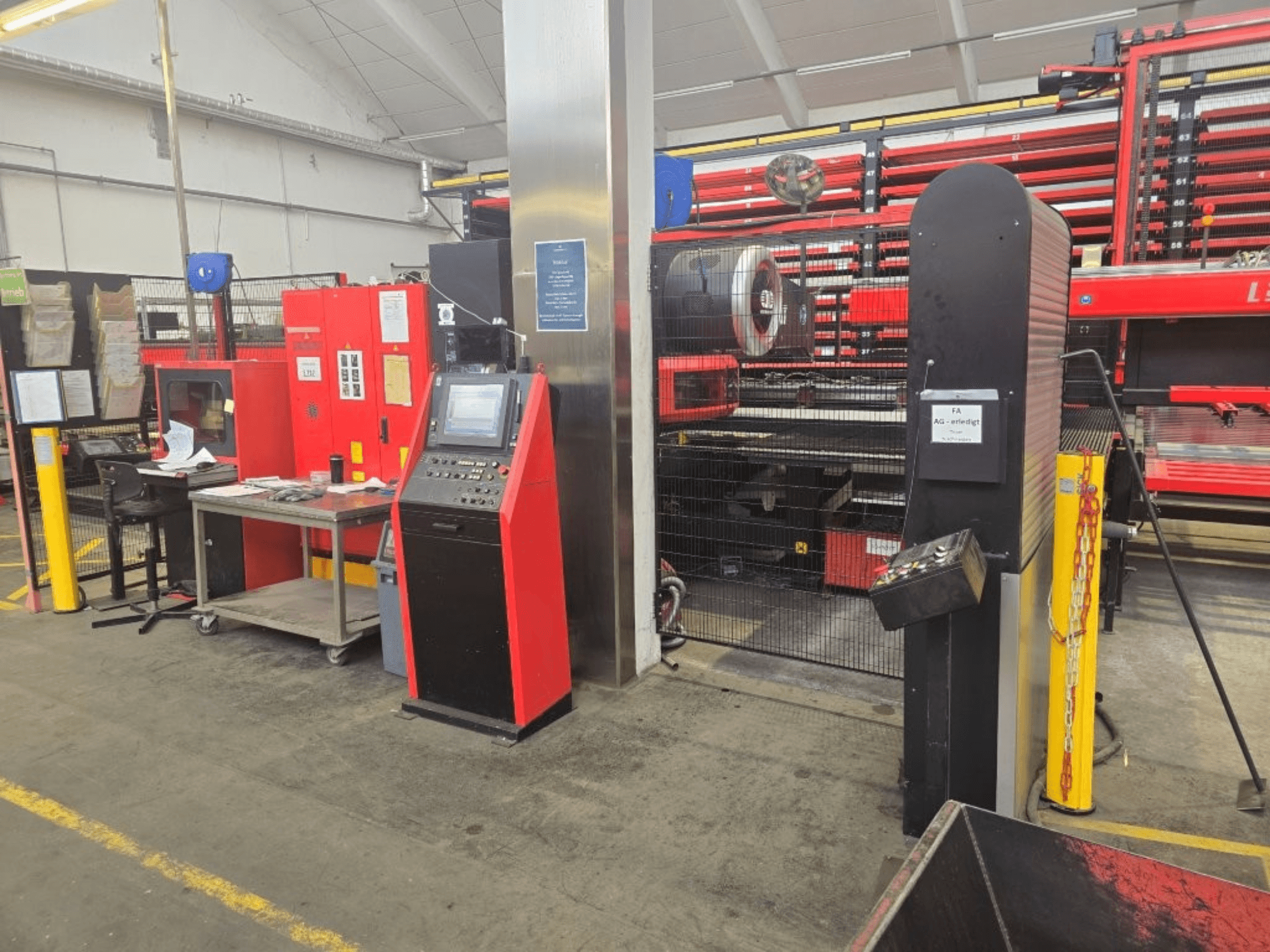 Framifrånvy av CNC-stansmaskinen AMADA EMZ 3610 NT, med manöverpanel och skyddshölje i en fabriksmiljö.