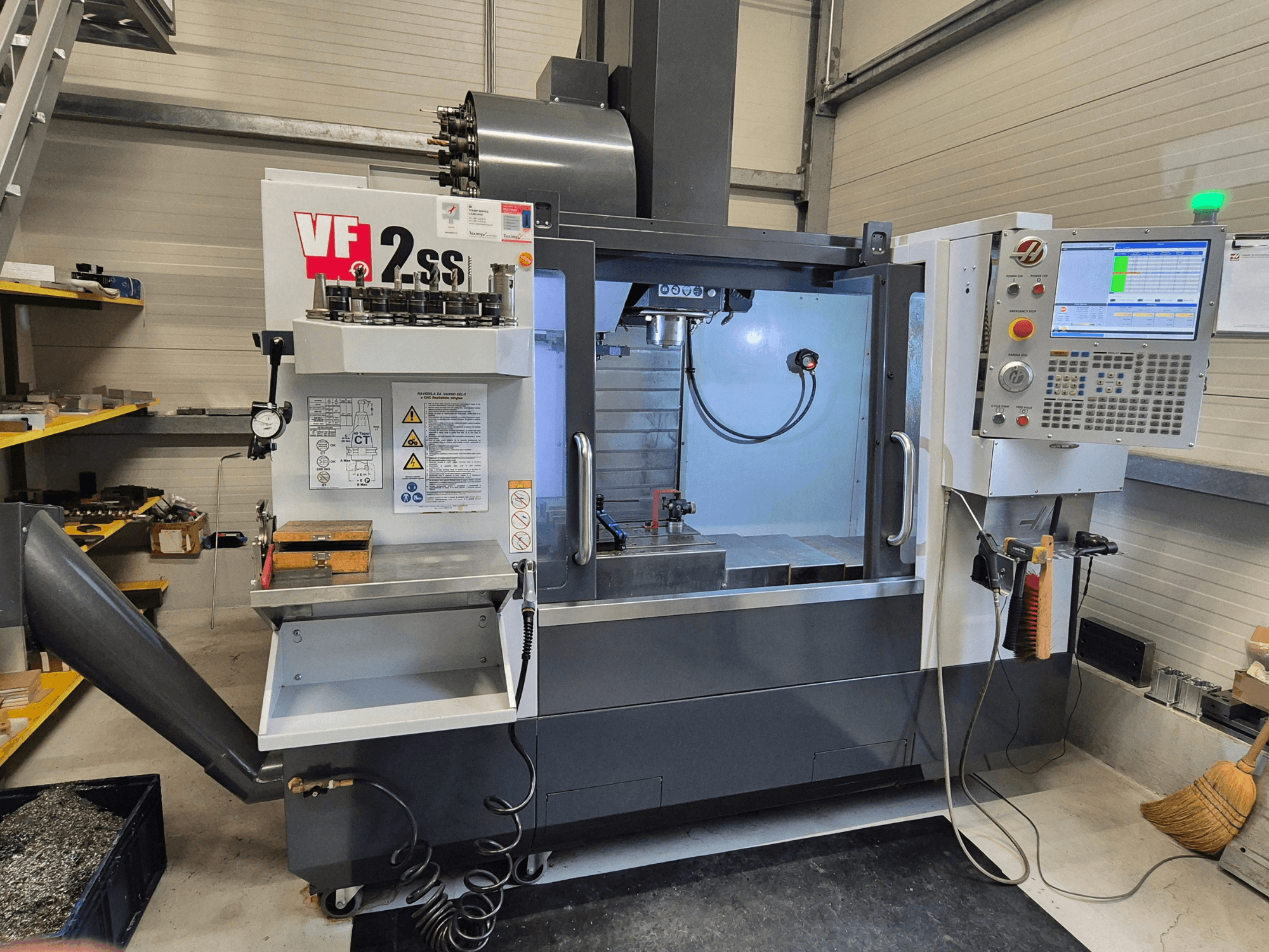 HAAS VF2 SS-EU vertikal fleroperationsmaskin framifrån, med kontroller, spindel och bearbetningsområde.